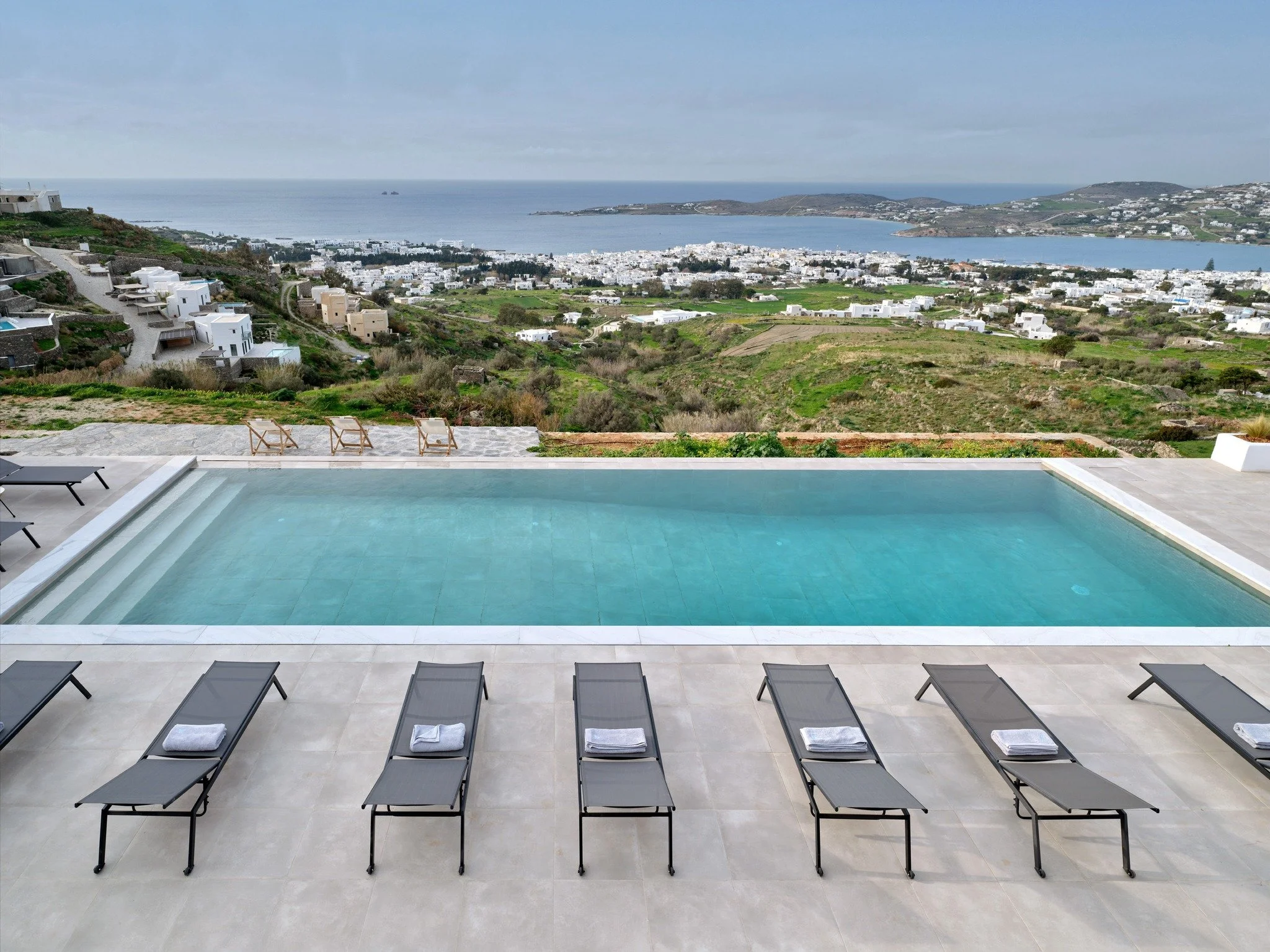 Welcome to our luxurious 6-bedroom villa nestled on the slopes of Paroikia, overlooking the stunning vistas of the Aegean Sea in Paros Island. This high-end retreat offers a blend of Cycladic charm and modern sophistication, boasting brand new facili