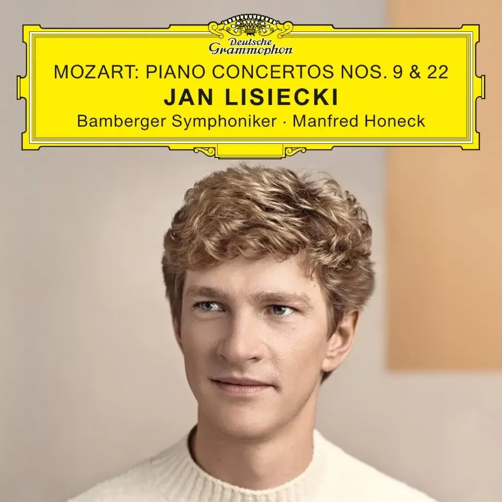 Album cover featuring a young man with curly blonde hair wearing a cream-colored sweater, with a yellow title banner at the top displaying information about a classical music concert featuring Jan Lisiecki performing Mozart piano concertos, conducted by Manfred Honeck.