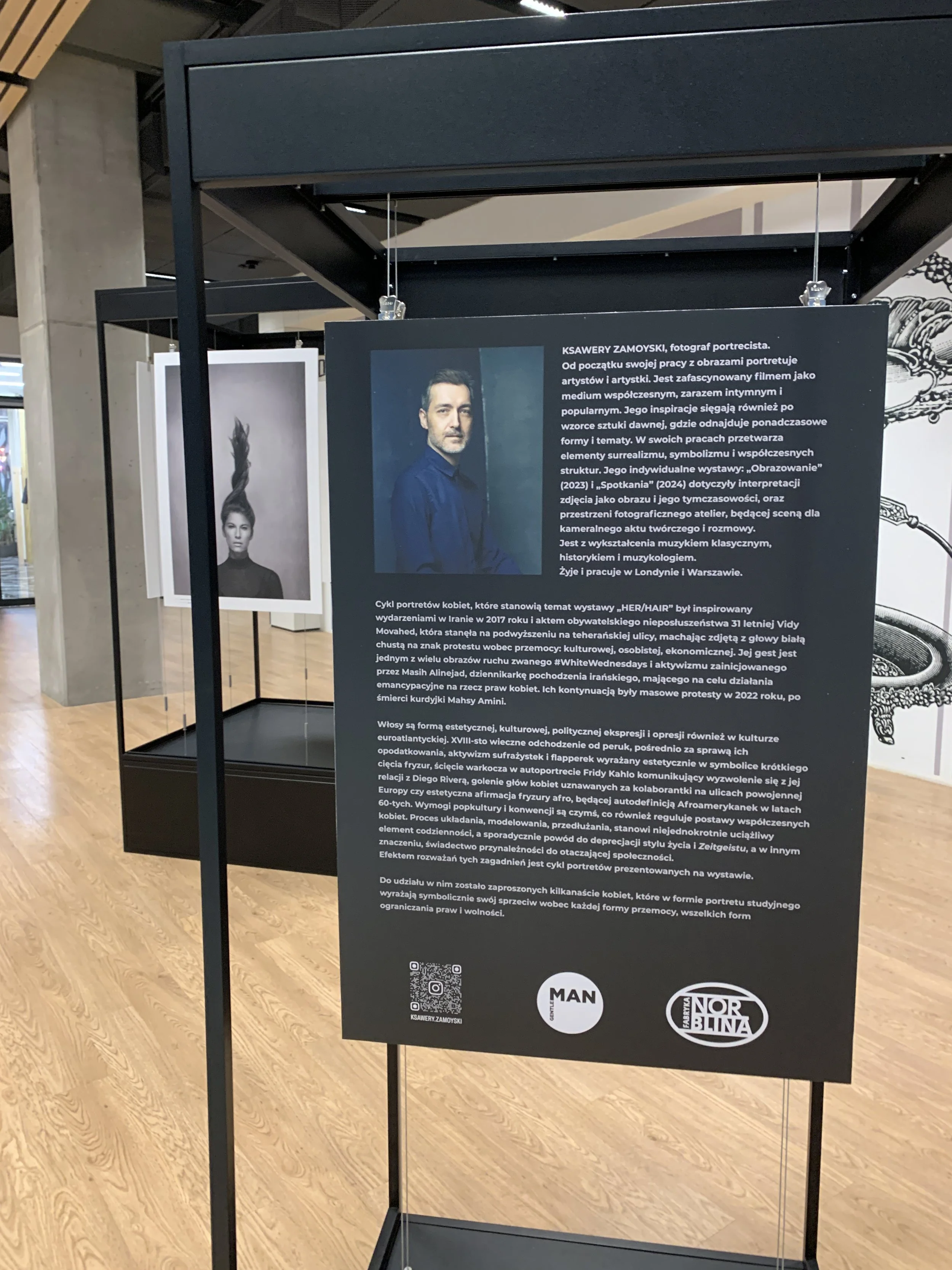 Information panel describing the artist Ksawery Zamoyski and his portrait cycle inspired by the women's movement, emphasizing aesthetics, culture, and political expression, displayed at an art exhibition.
