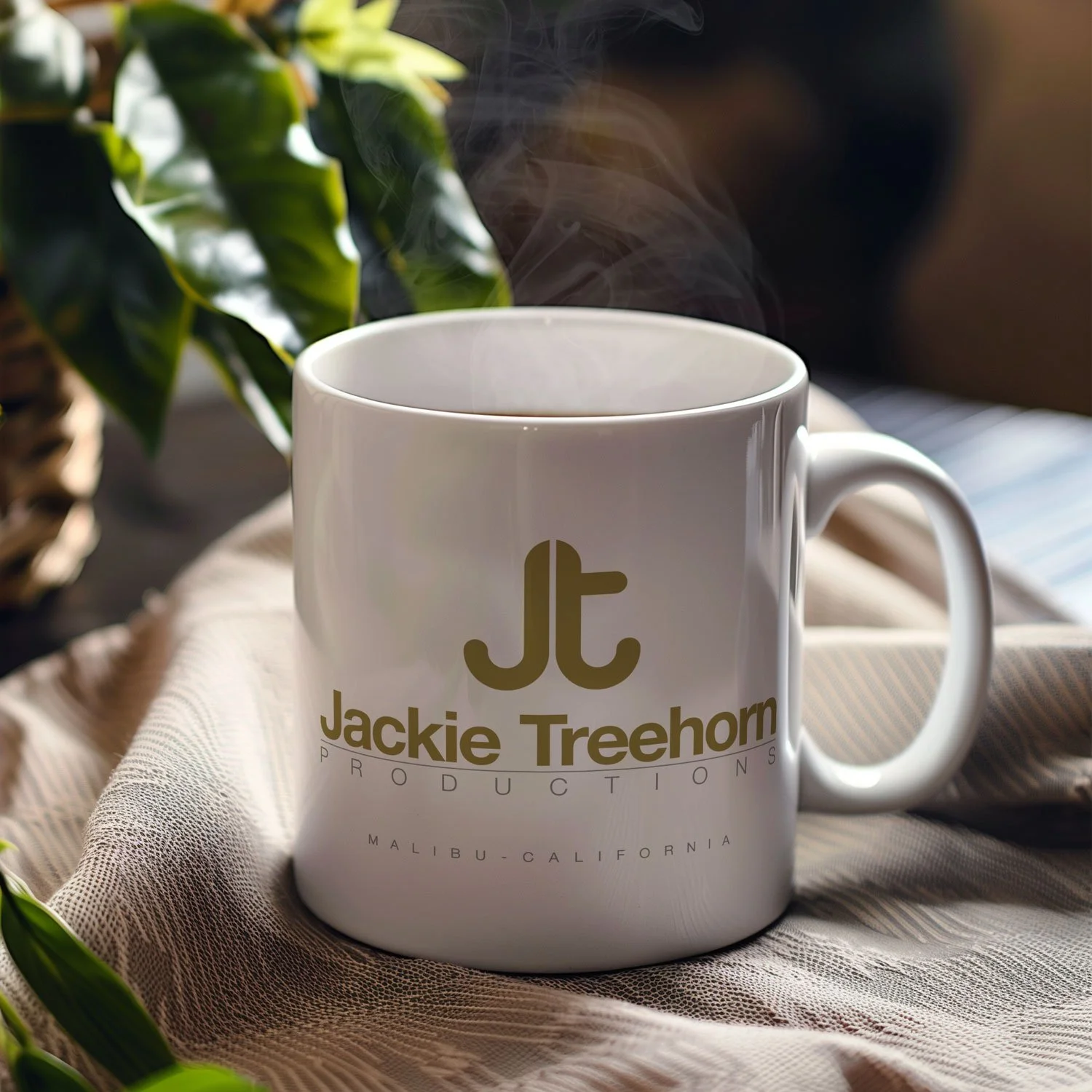 A Jackie Treehorn Productions Mug is displayed on a table, filled with coffee.