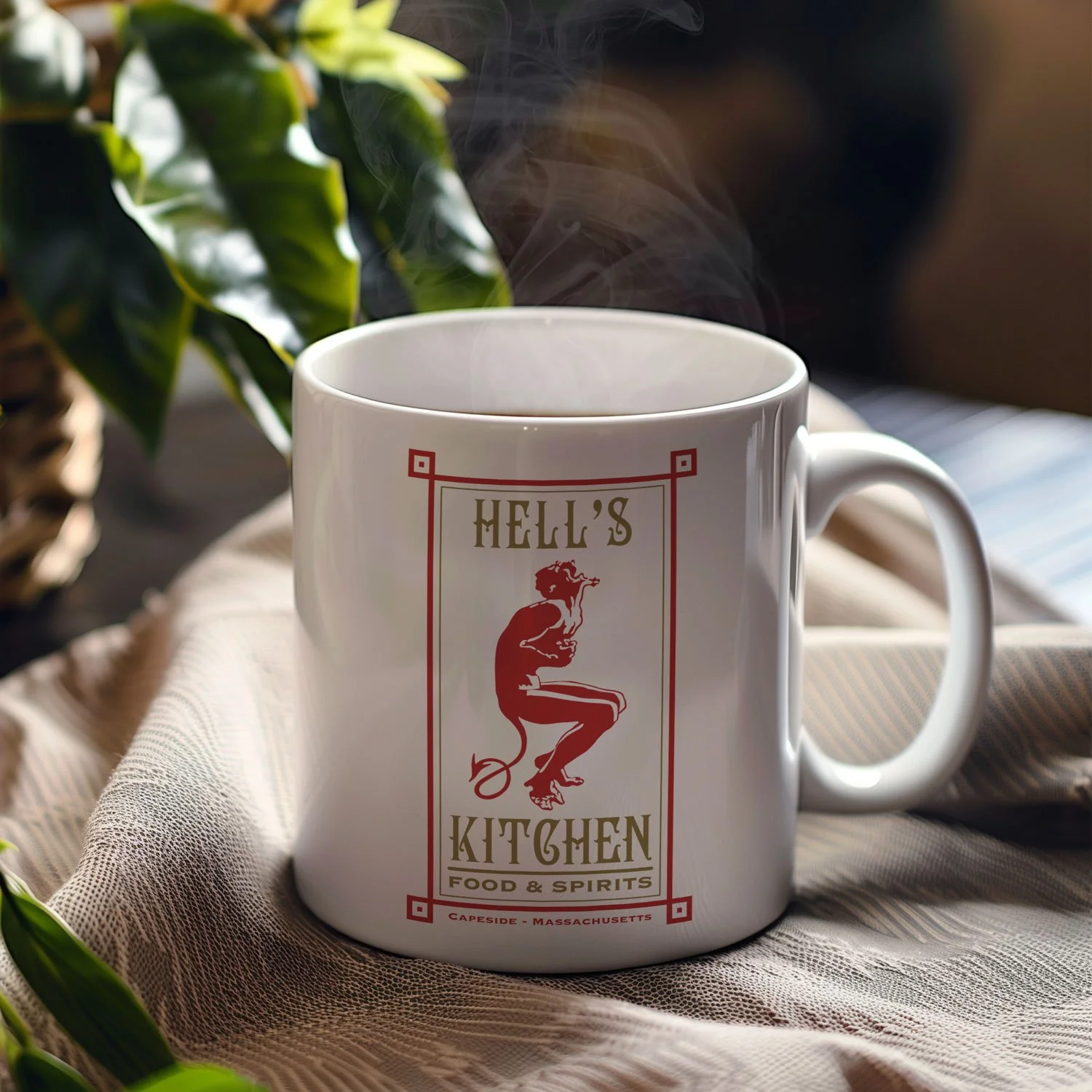 A Hell's Kitchen mug is displayed on a table, filled with coffee.