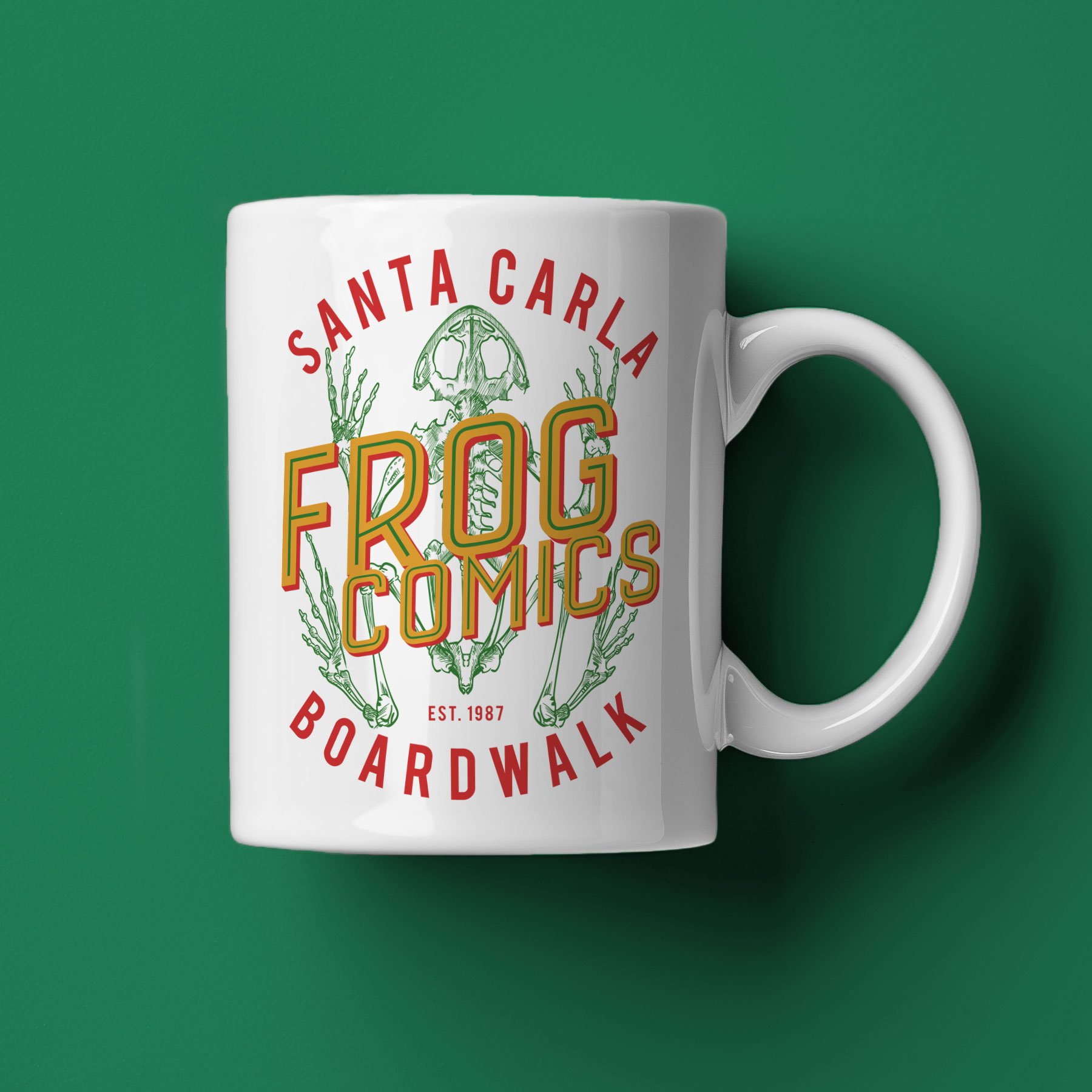 A Frog Comics Mug lies on its side against a dark green background.