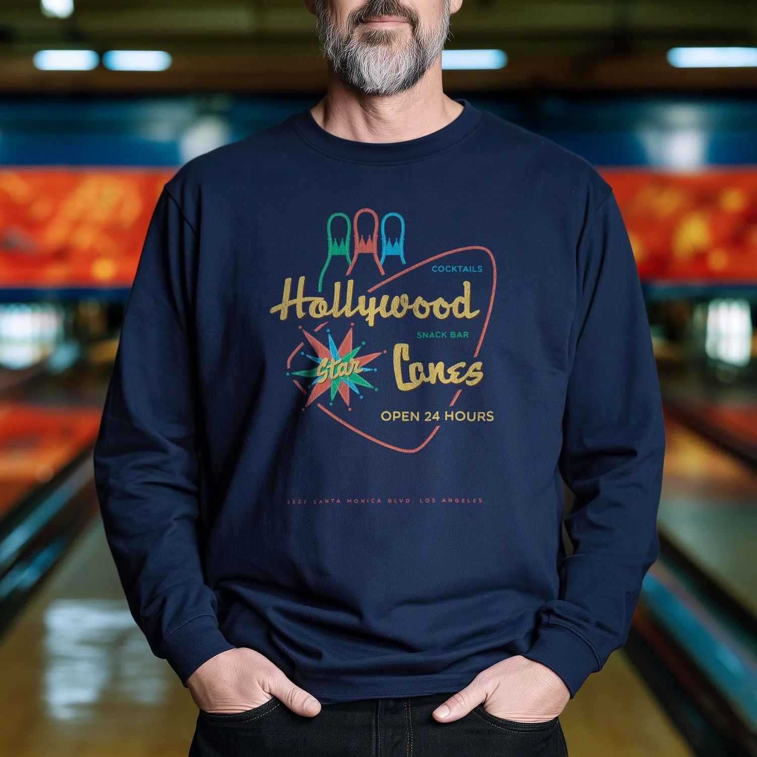 Image of a man wearing a Hollywood Star Lanes long-sleeve T-shirt in a bowling alley.