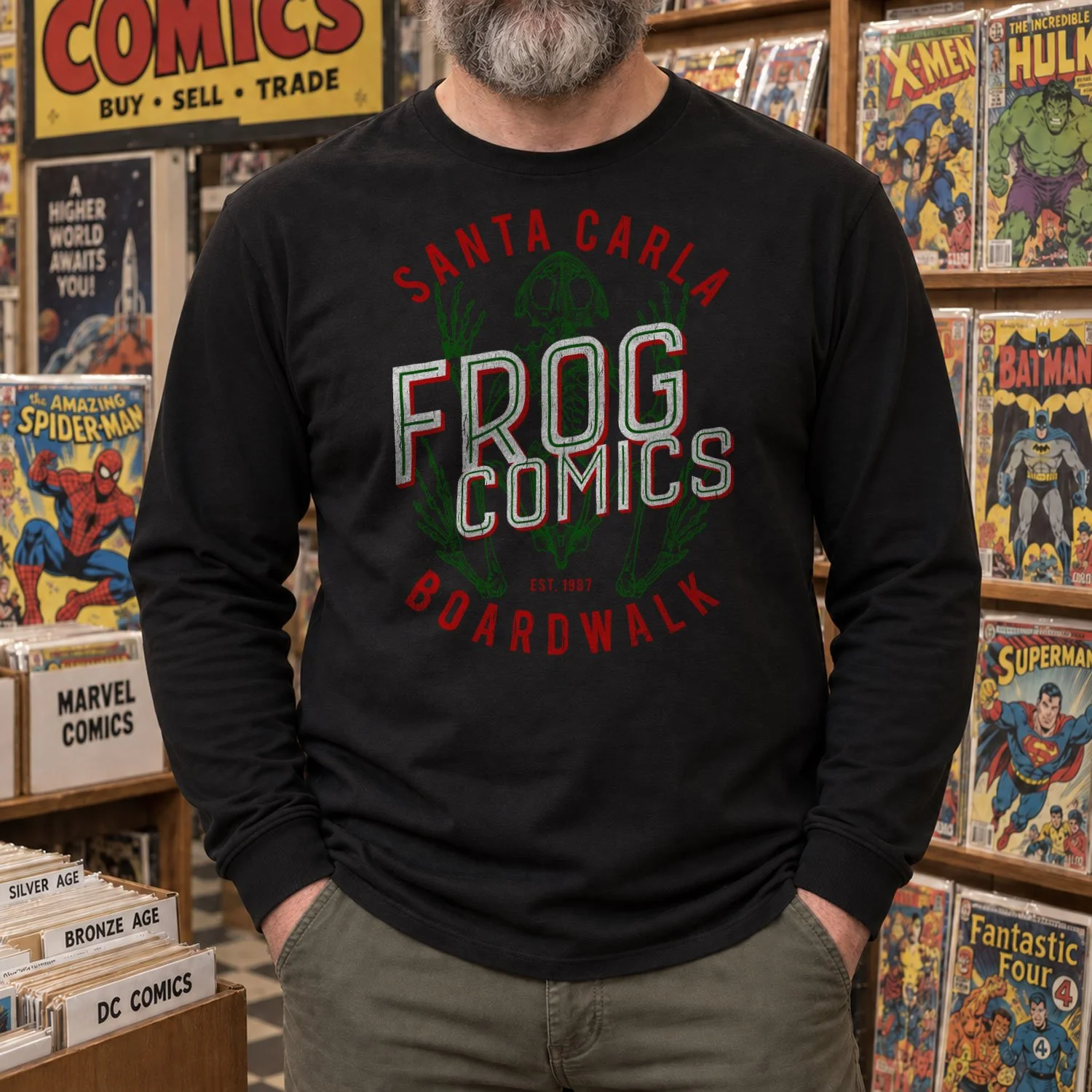 A man is wearing a Frog Comics long-sleeve T-shirt while standing in a retro comic book store.