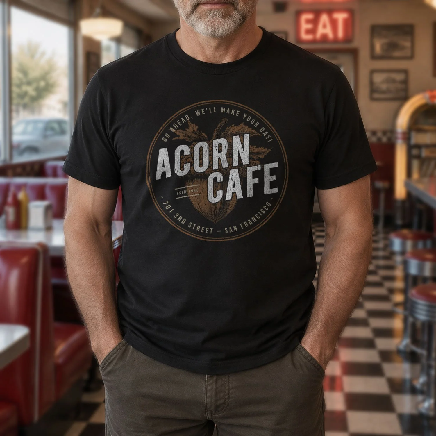 Image of a man wearing an Acorn Cafe T-shirt in a classic cafe diner.