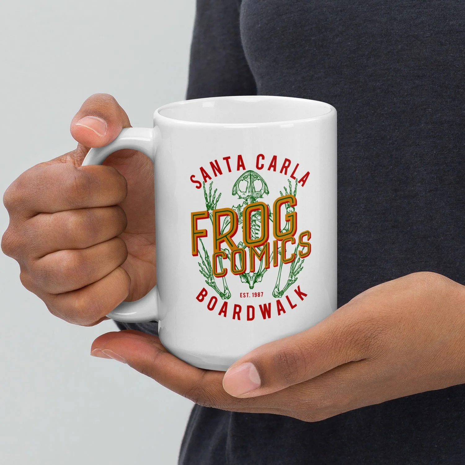 Close-up of a man holding a 15-oz Frog Comics Mug.