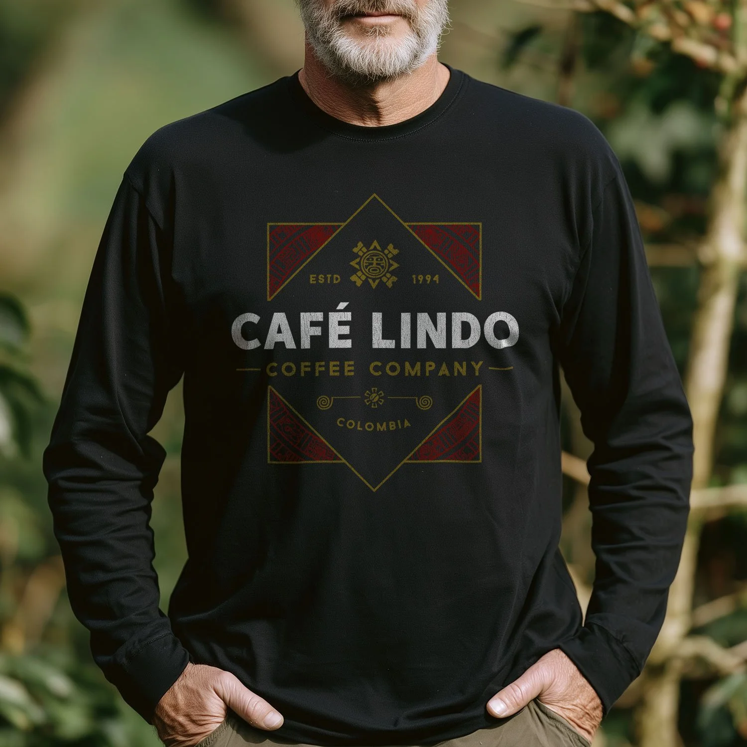 Image of a man wearing a Café Lindo long-sleeve T-shirt in a coffee plantation landscape.