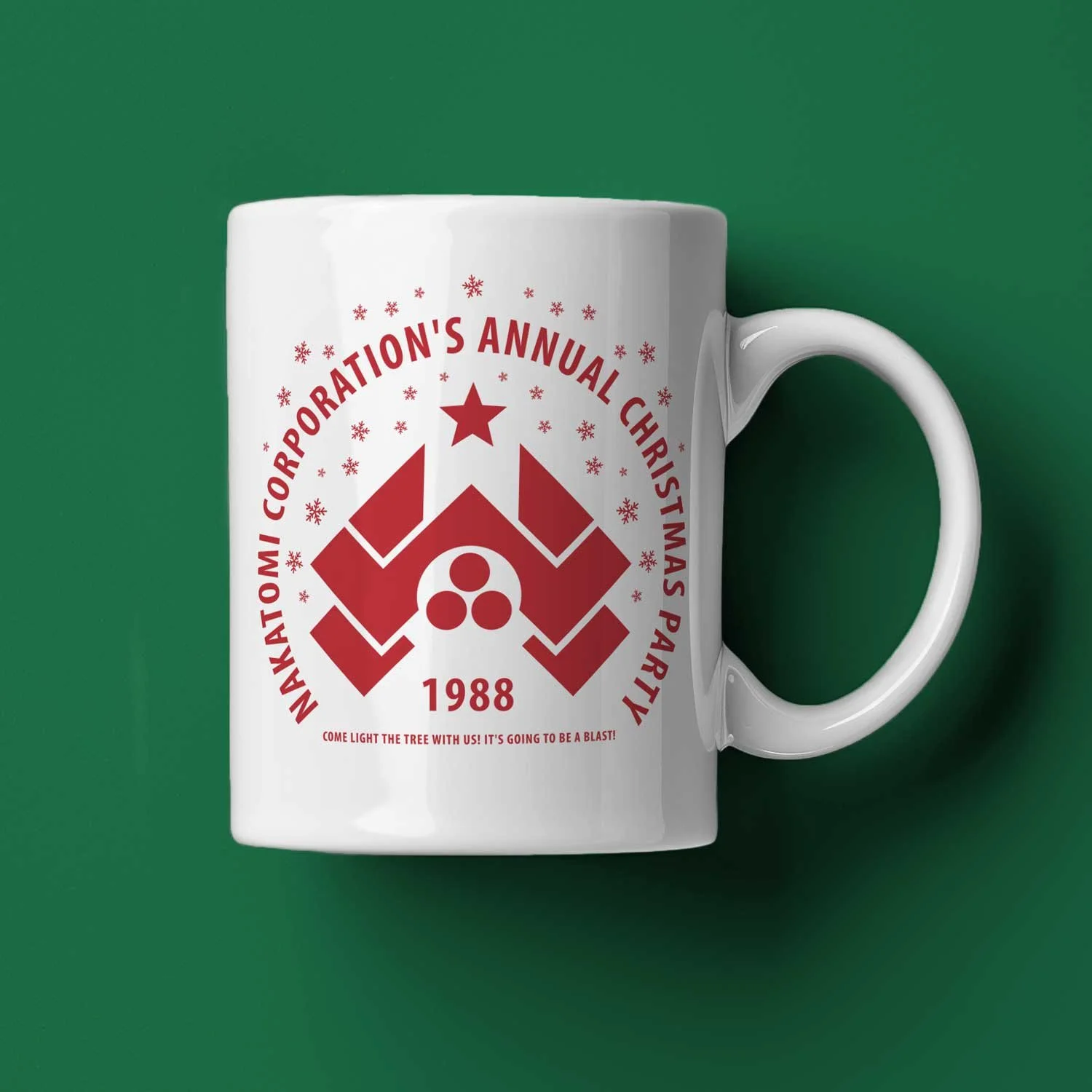 A Nakatomi Christmas Party mug lying on its side on a dark green Christmas background.
