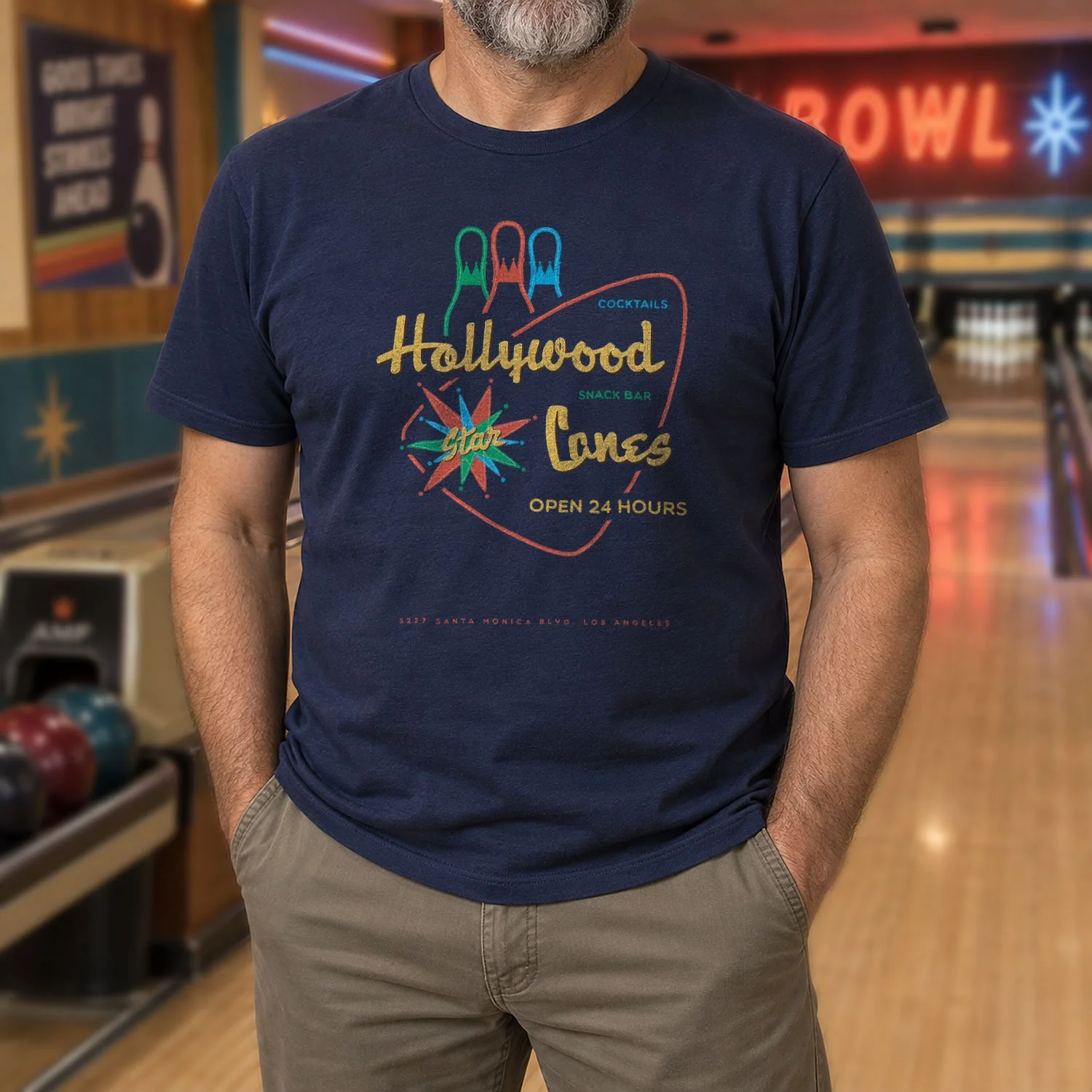 Image of a man wearing a Hollywood Star Lanes short-sleeve T-shirt in a bowling alley.