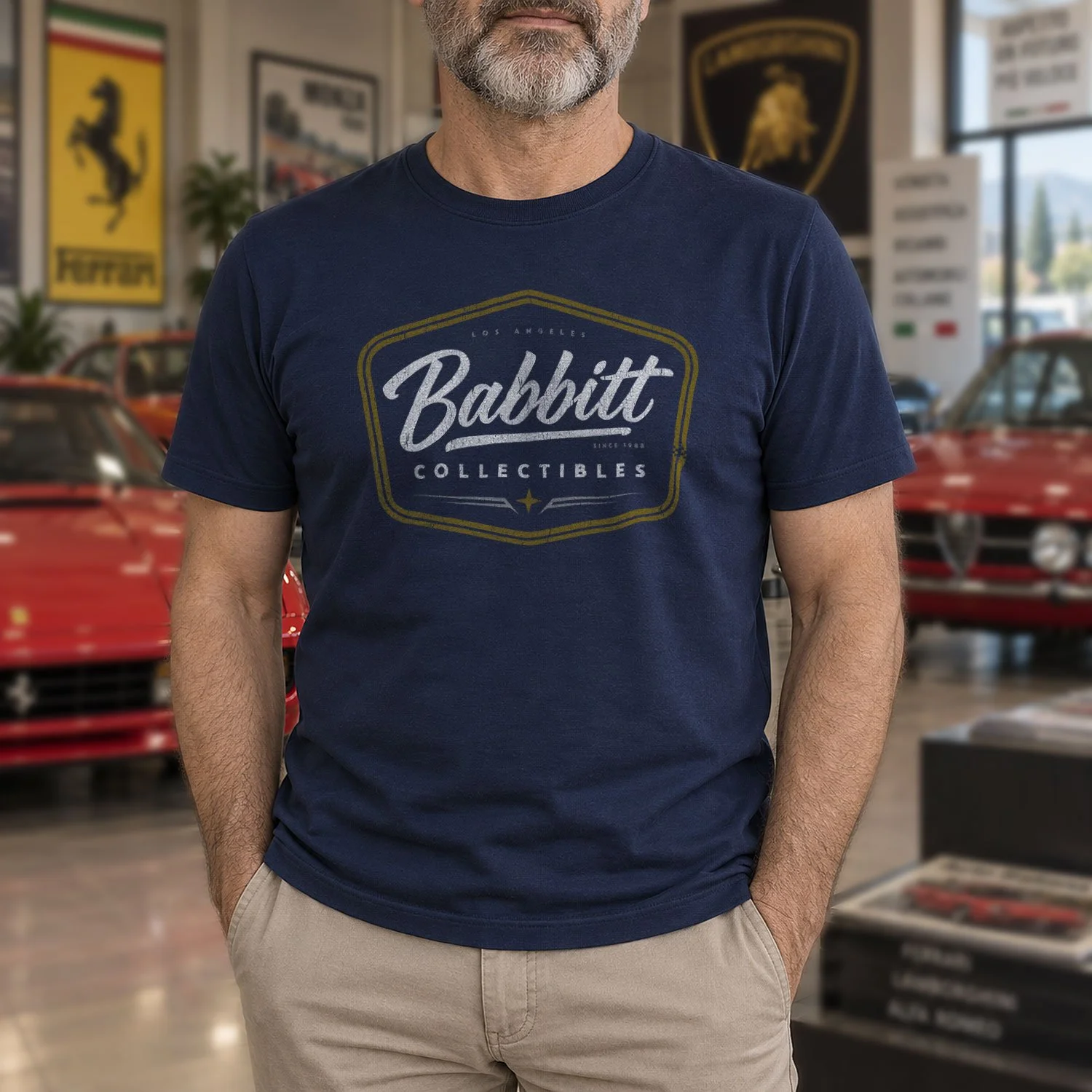 Image of a man in a Babbitt Collectibles T-shirt standing in front of several retro 1980s Italian sports cars.