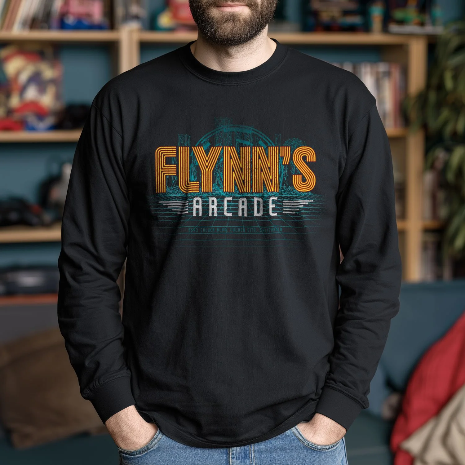 Image of a man wearing an Flynn’s Arcade long sleeve T-shirt in a retro arcade.