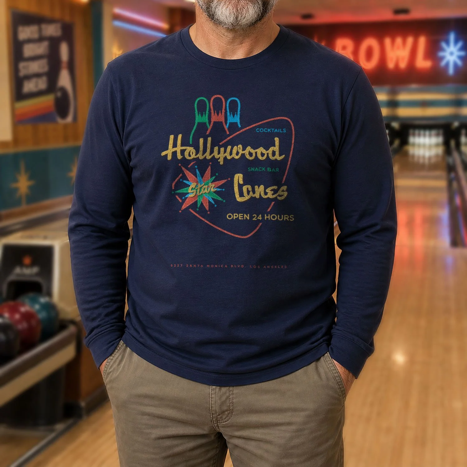 Image of a man wearing a Hollywood Star Lanes long-sleeve T-shirt in a bowling alley.