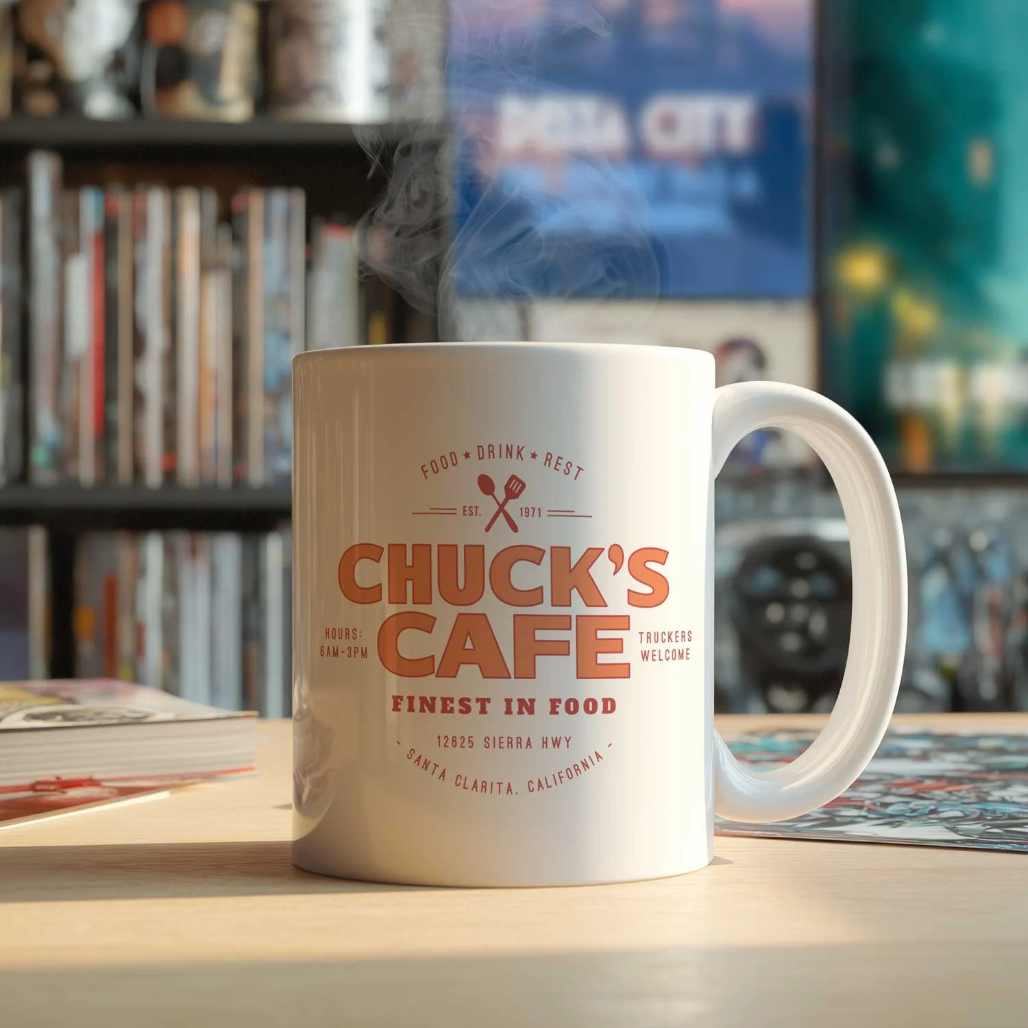 A Chuck's Cafe mug is displayed on a table, filled with coffee.