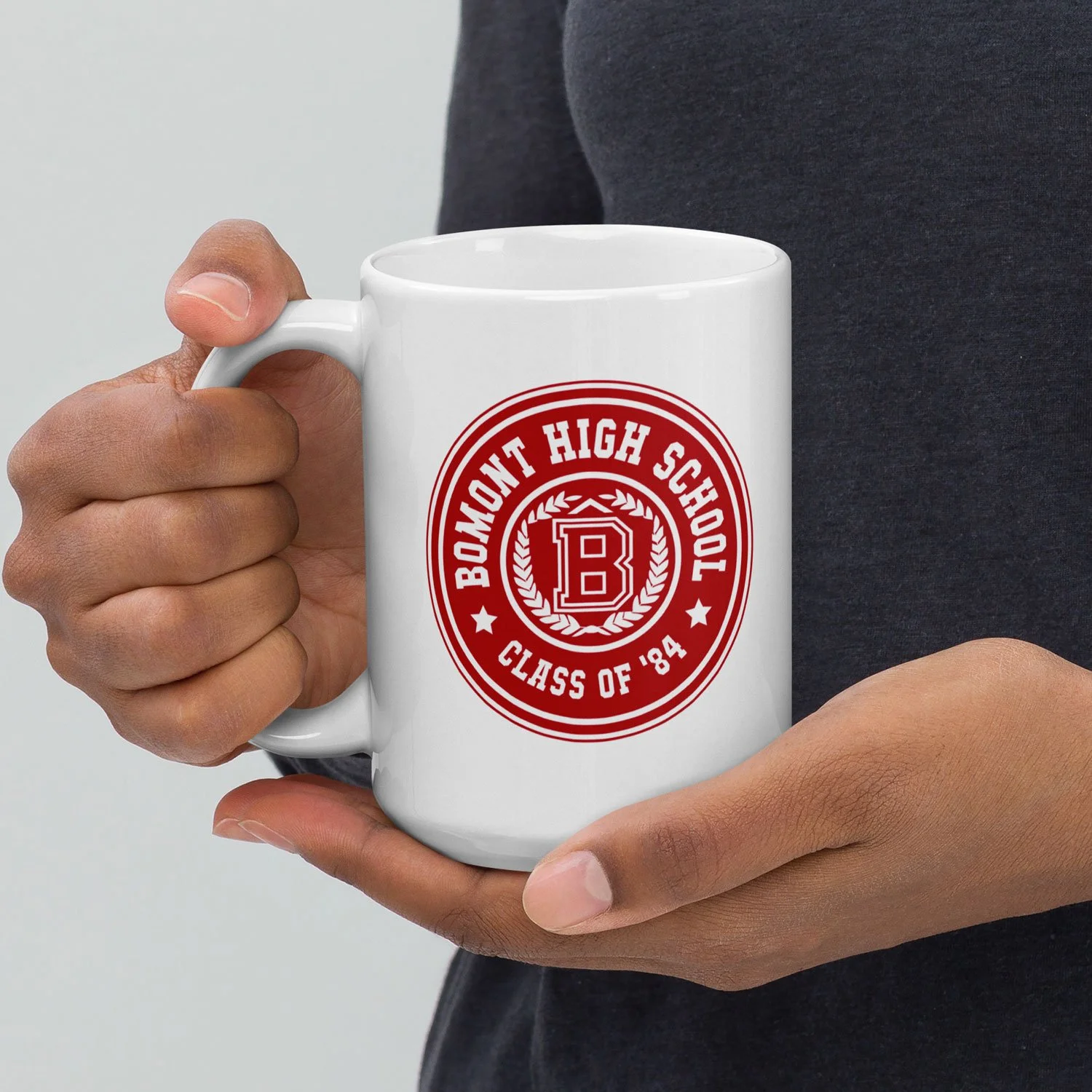 Close-up of a man holding a 15-oz Bomont High School Mug.