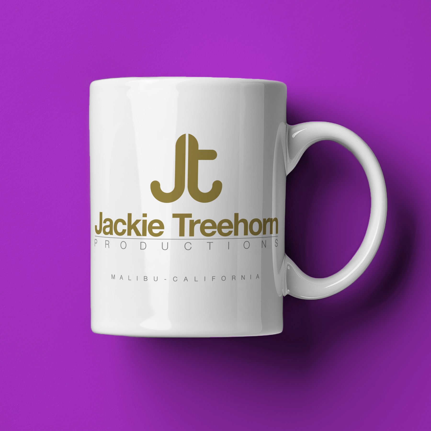 A Jackie Treehorn Productions Mug lies on its side against a purple background.
