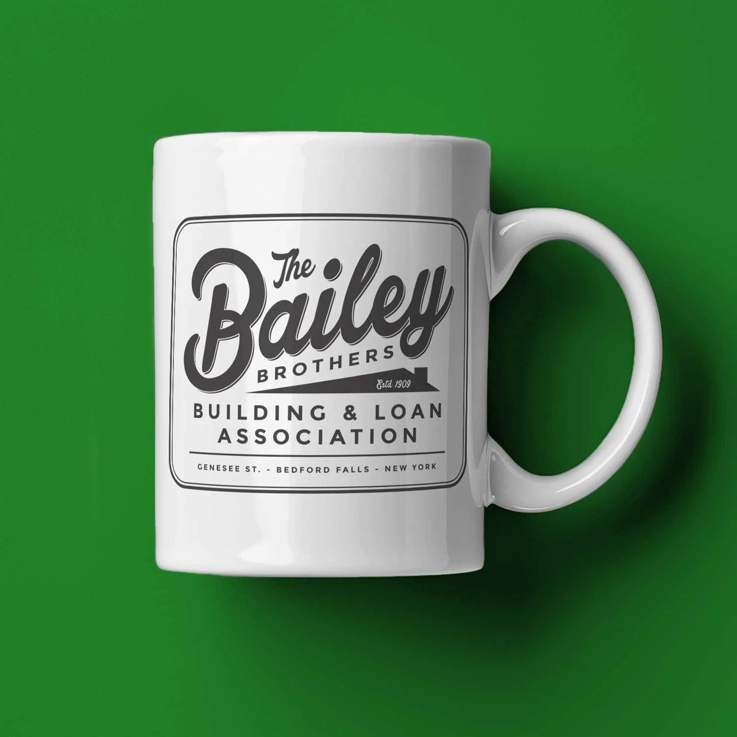 A Bailey Brothers mug lying on its side on a green Christmas background.