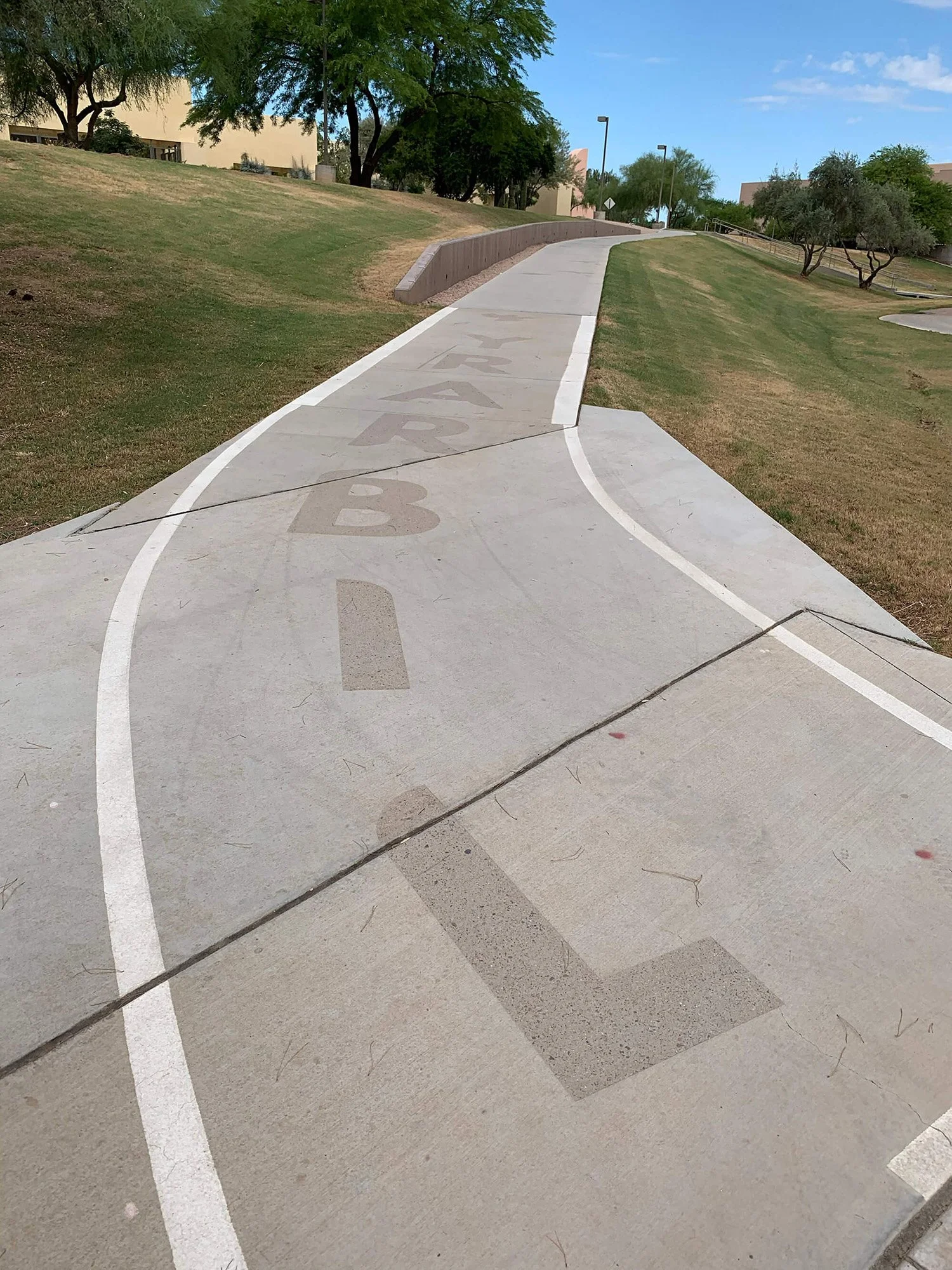 Library wayfinding text sandblasted into sidewalk