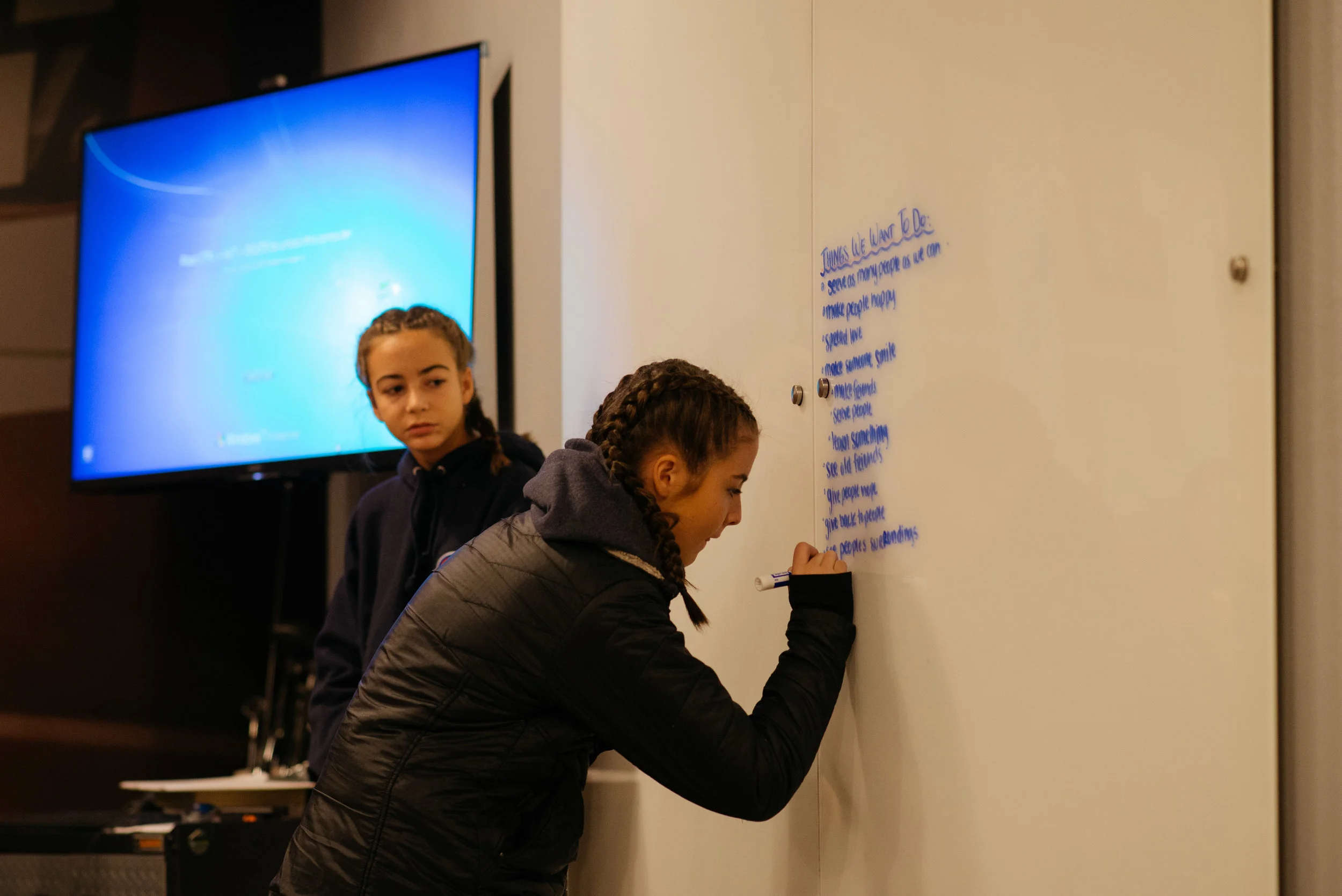 Izzy writing down what the Youngers hope to accomplish while they serve.