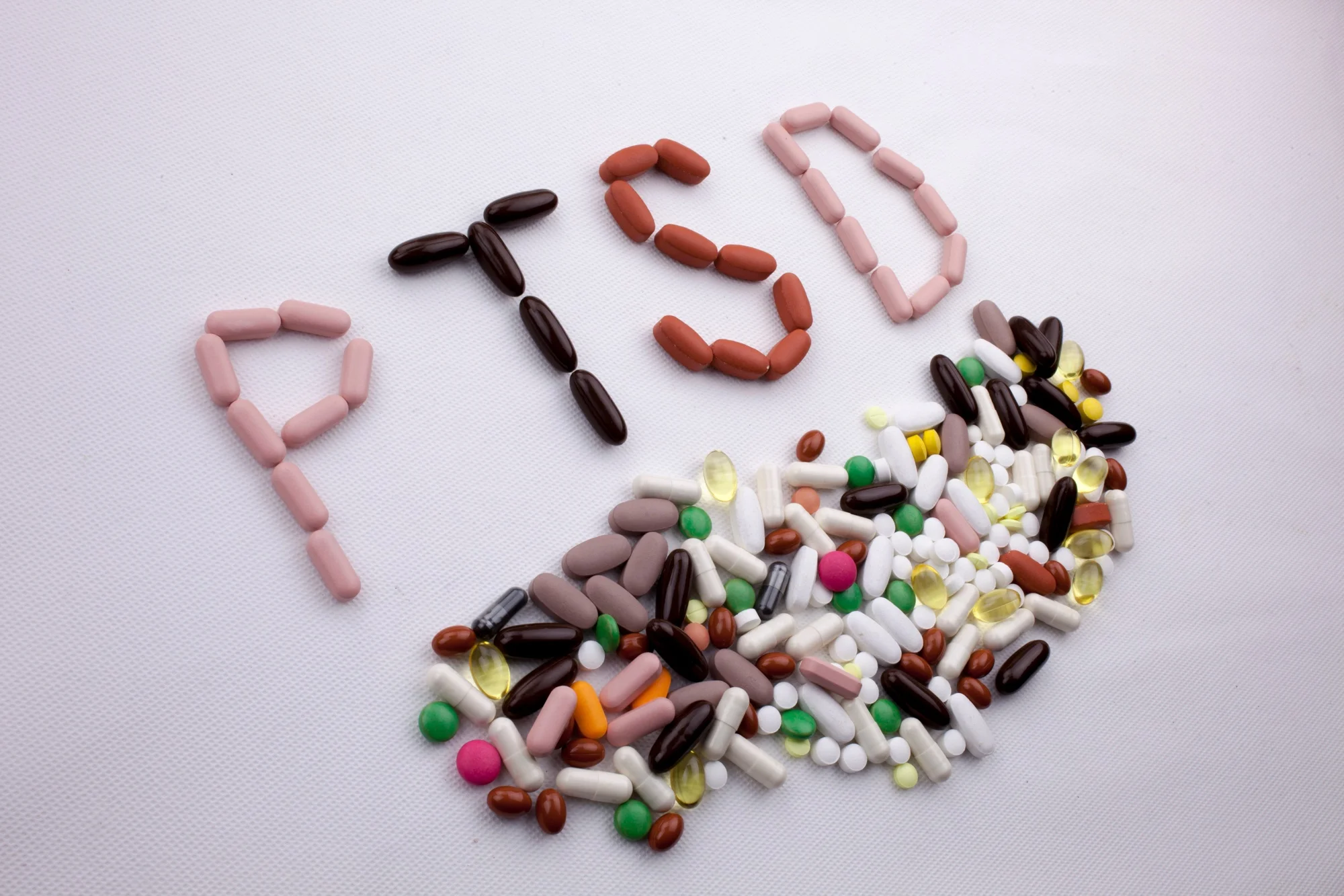 Conceptual Hand writing text caption inspiration Medical care Health concept written with pills drugs capsule word PTSD On white isolated background with copy space.jpg
