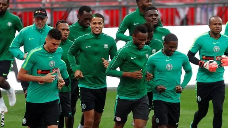 Visiting players relax by singing at the piano before friendly