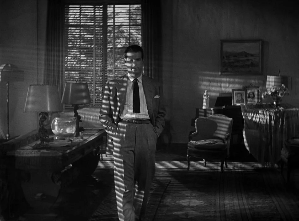 Fred MacMurray, framed by typical noir lighting, symbolically representing prison bars