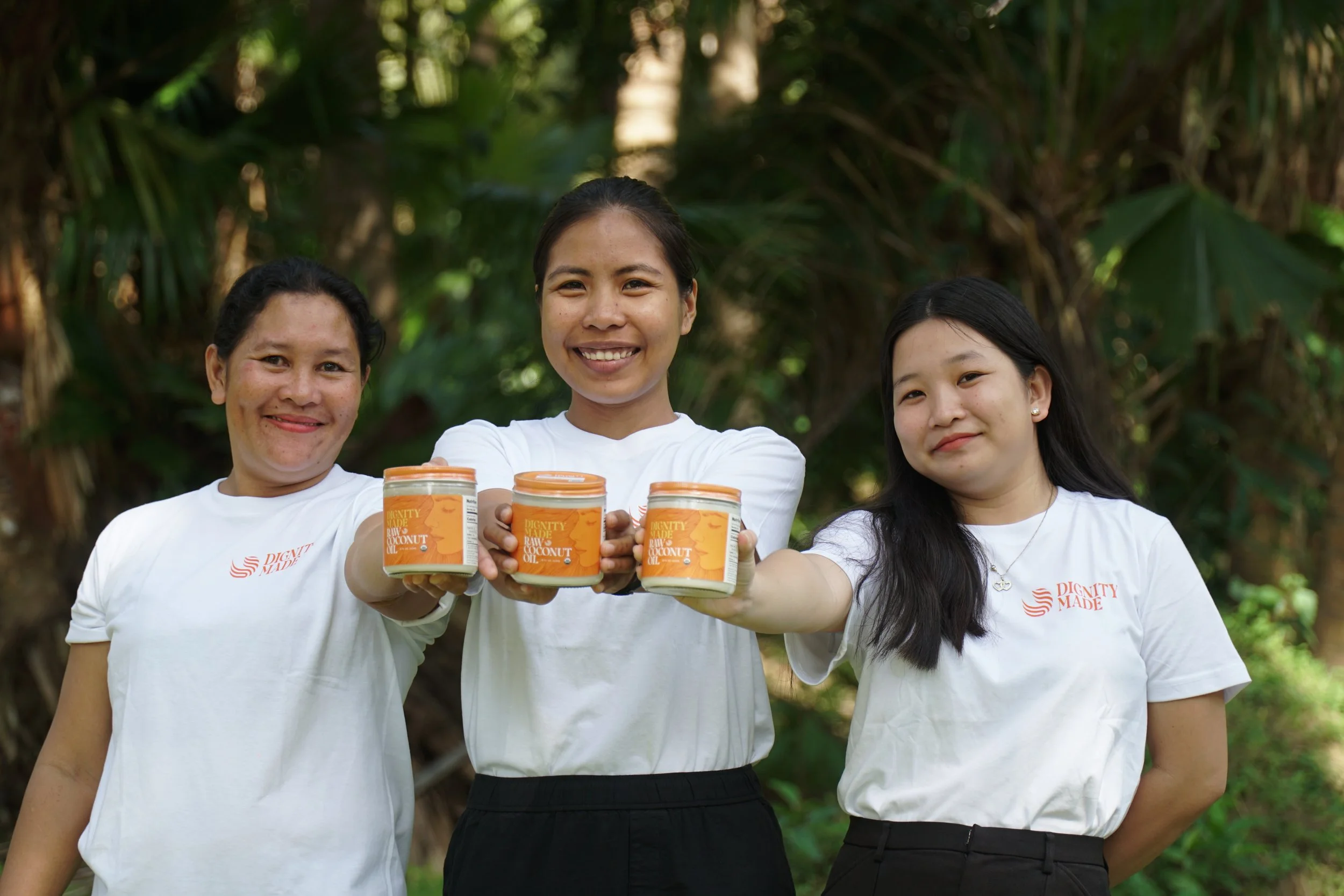 Dignity Made - Three Women Holding out Jar.JPG