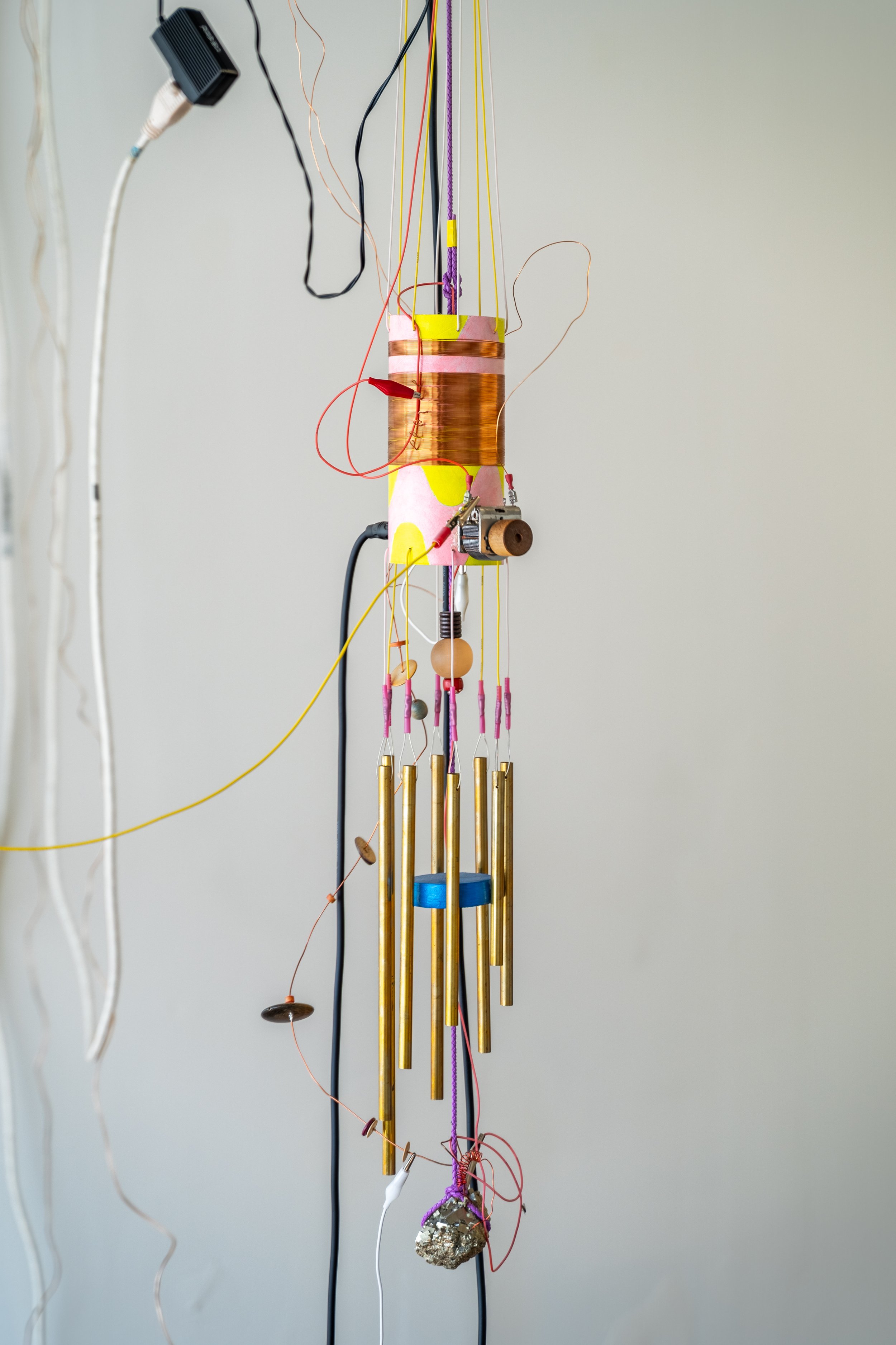  Peter Simensky  Pyrite Radio - Chimes (Yellow/Pink) , 2021  Pyrite (fool's gold), copper, electrical wires, bead work, feathers, cardboard tube, paint, amplifiers, and radio hardware 