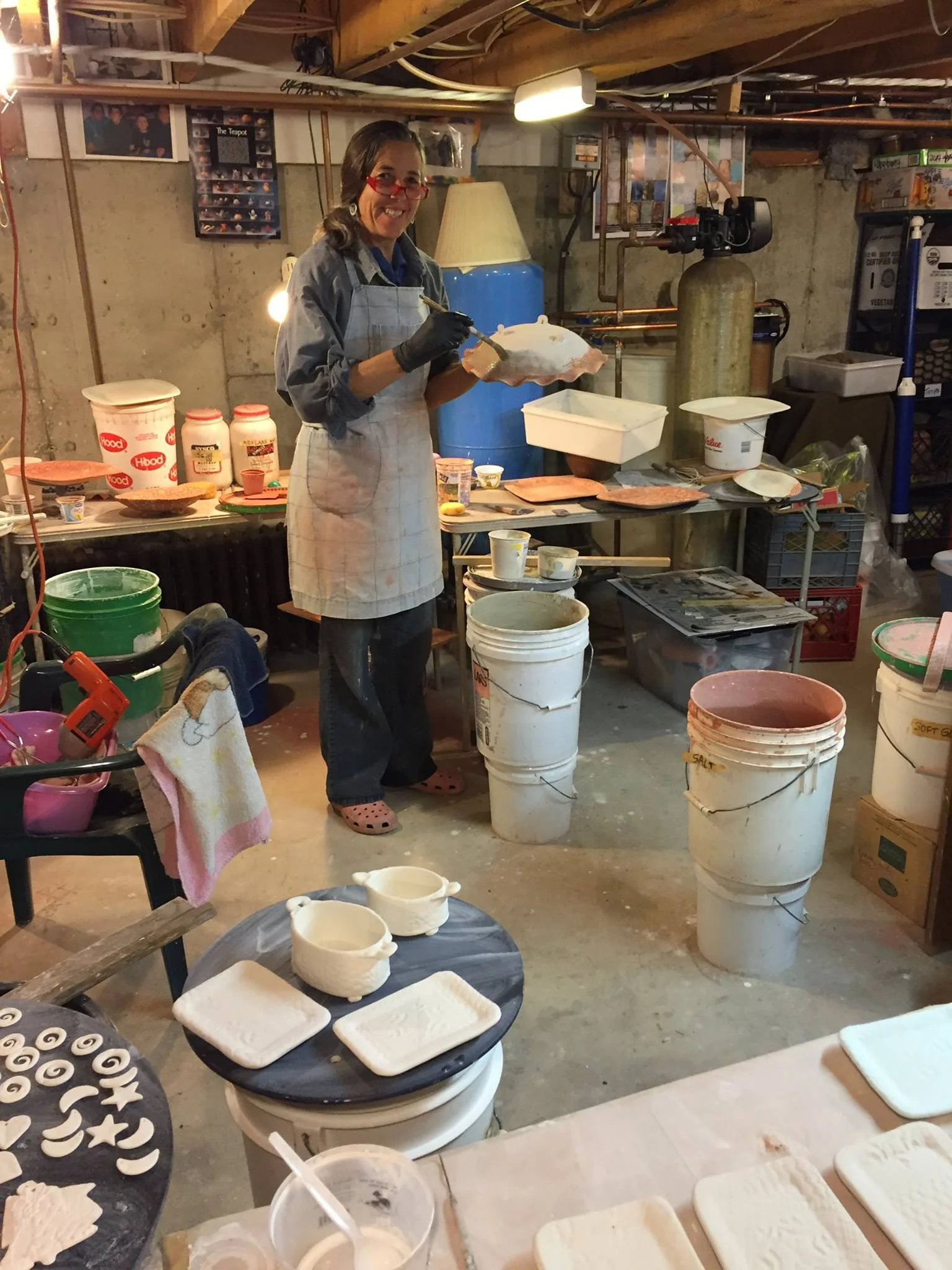 Jennifer in her ceramics studio applying glazes.