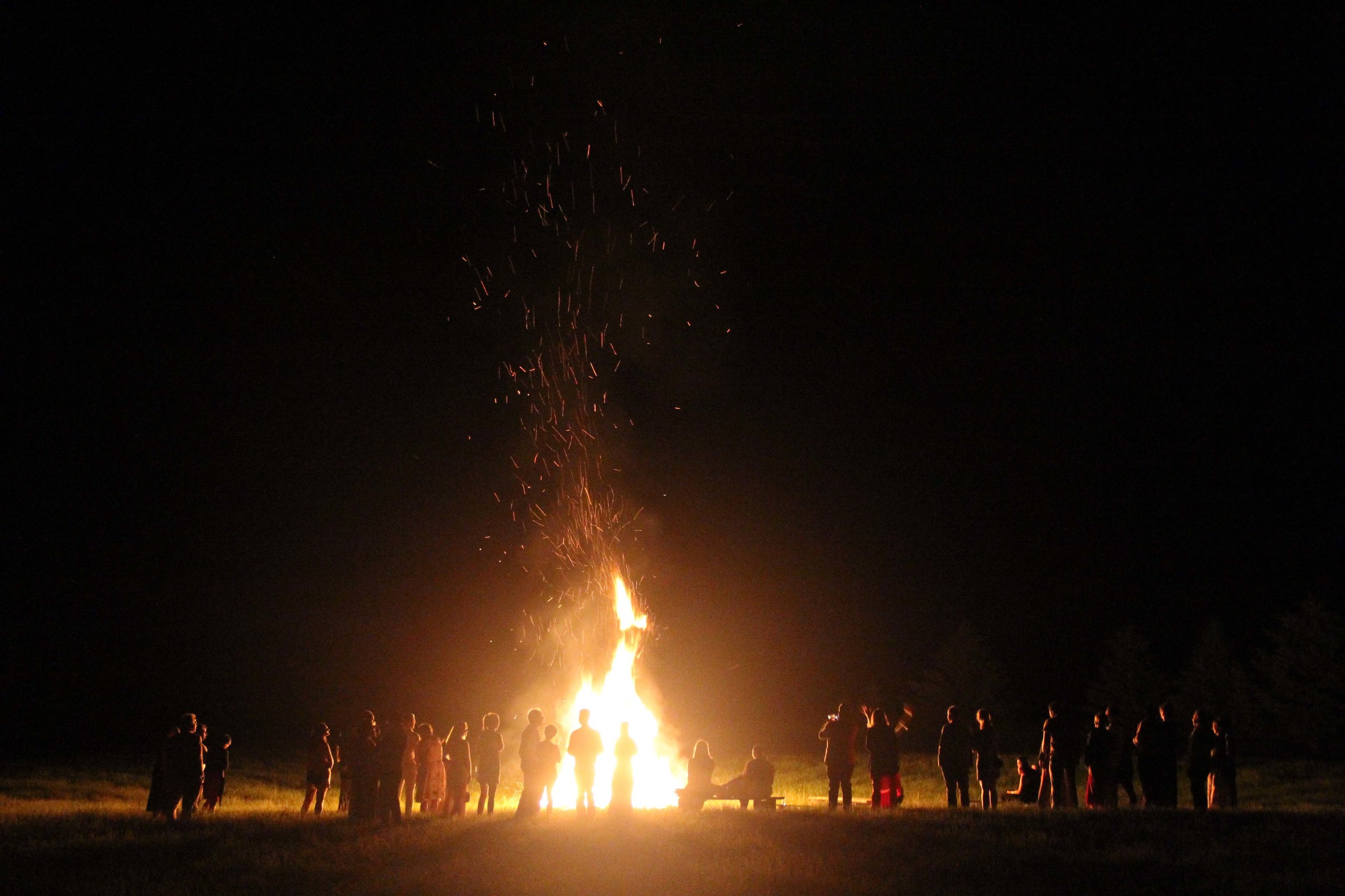 People gathered around a bonfire at night 