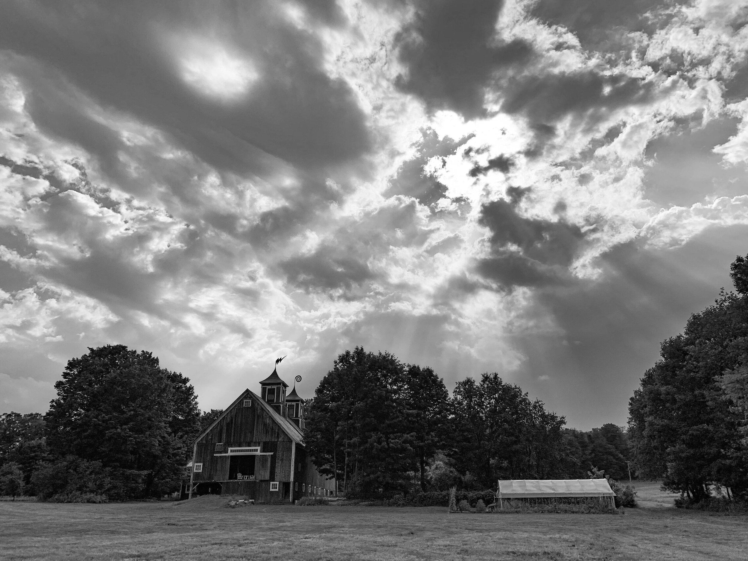A black and white photo of a cloudy day on the farm