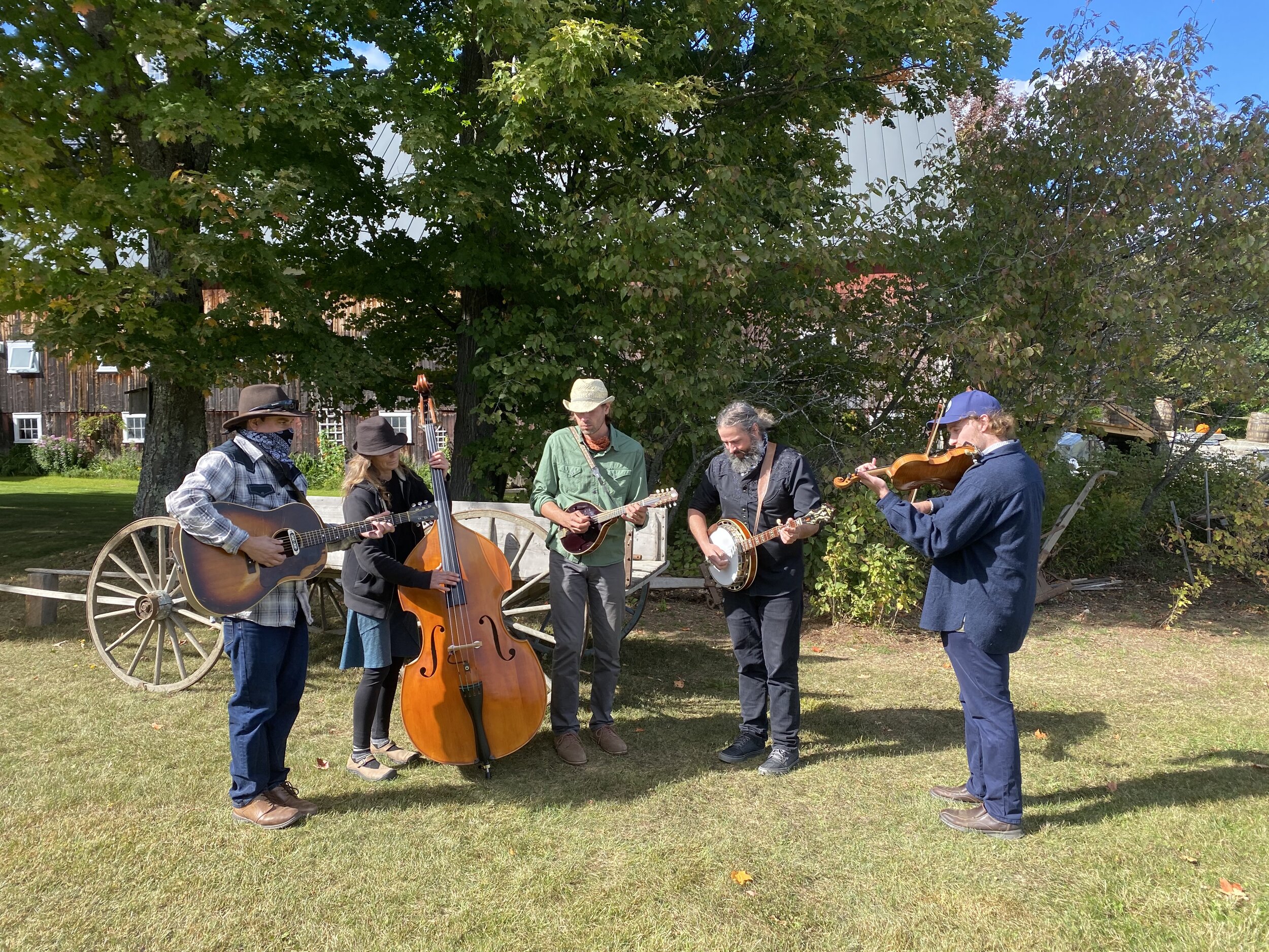 A bluegrass band playing by a rustic wagon outside