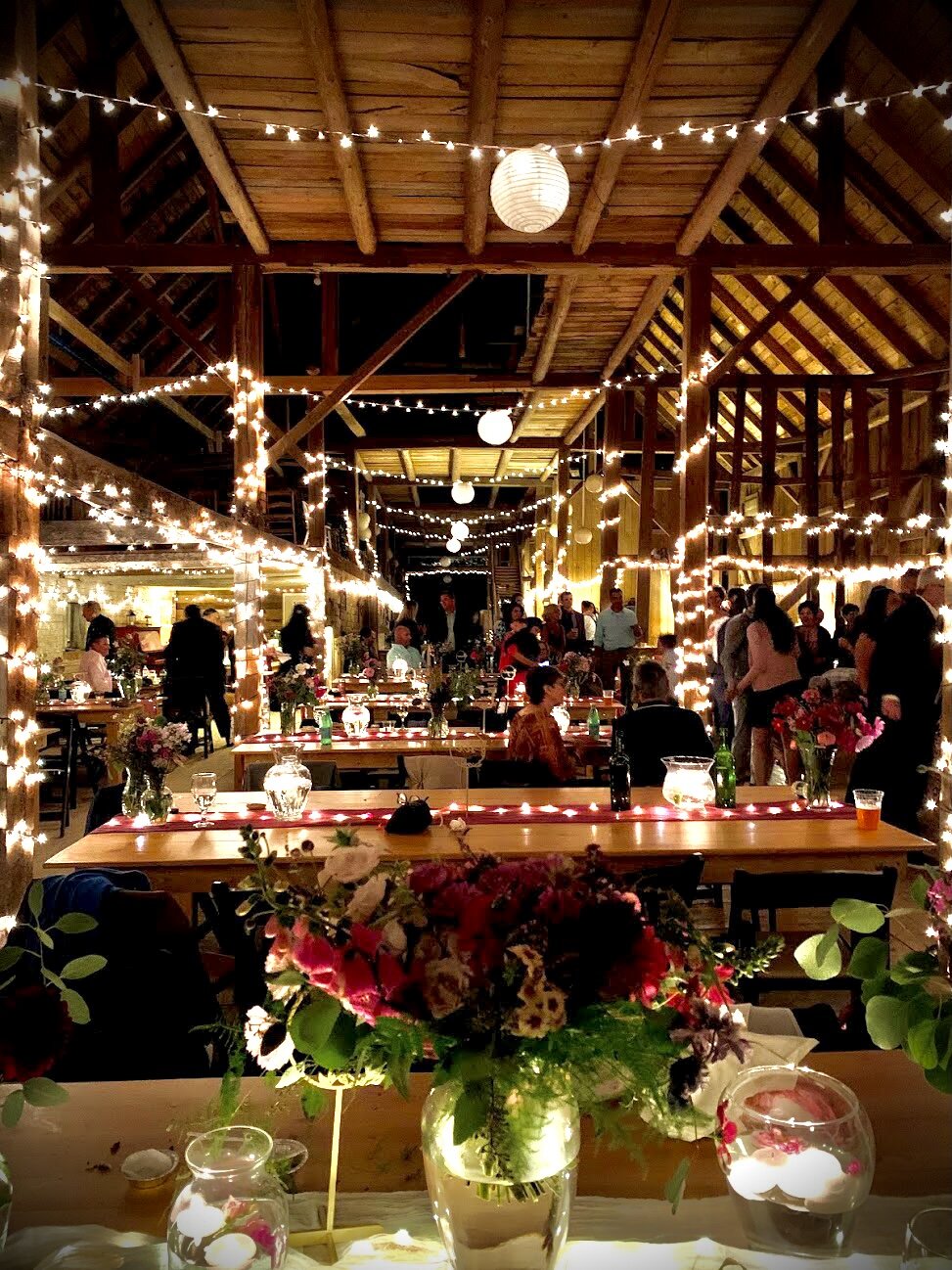 A view of a wedding reception at night lit with twinkle lights 