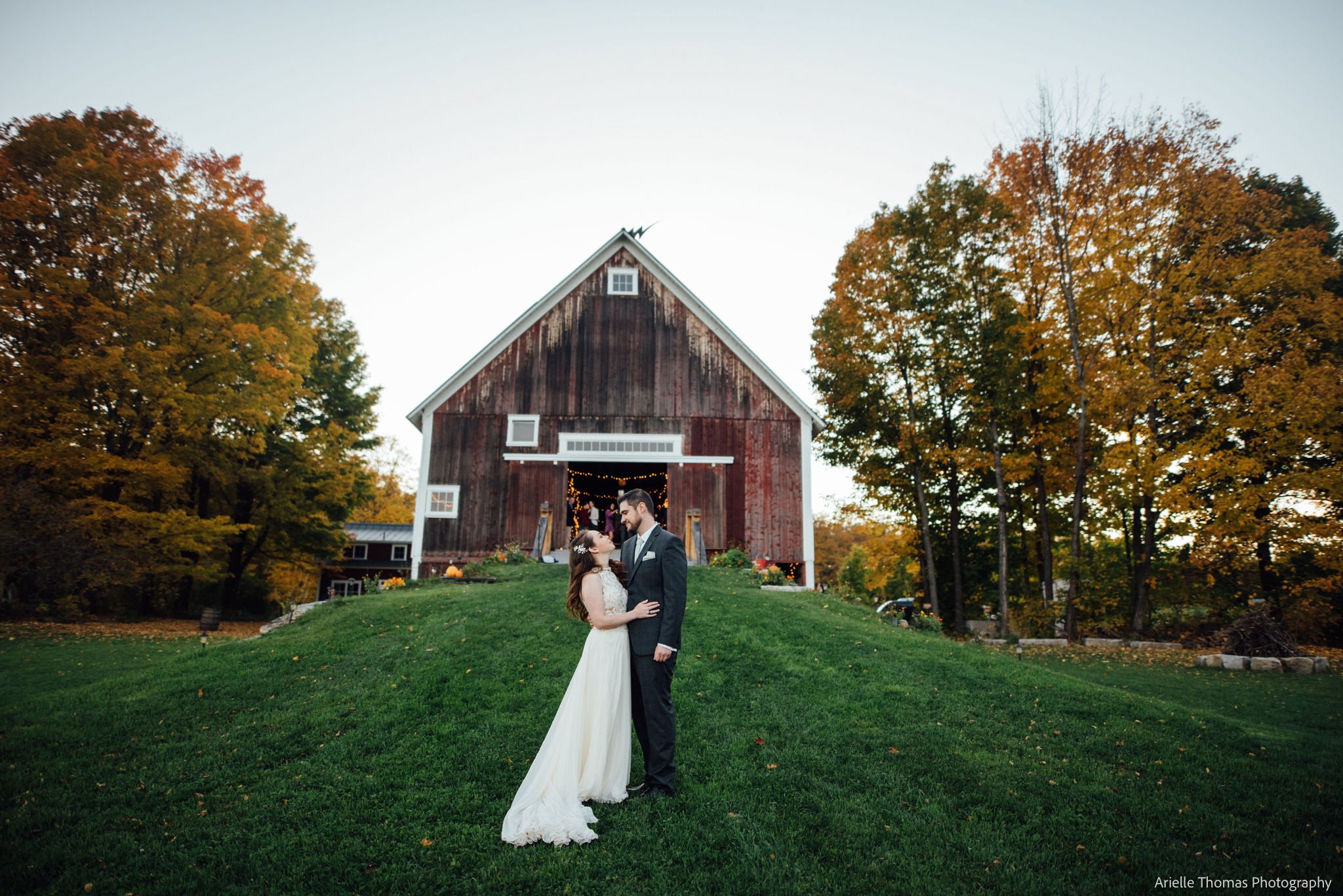 Married couple in front of barn in Vermont