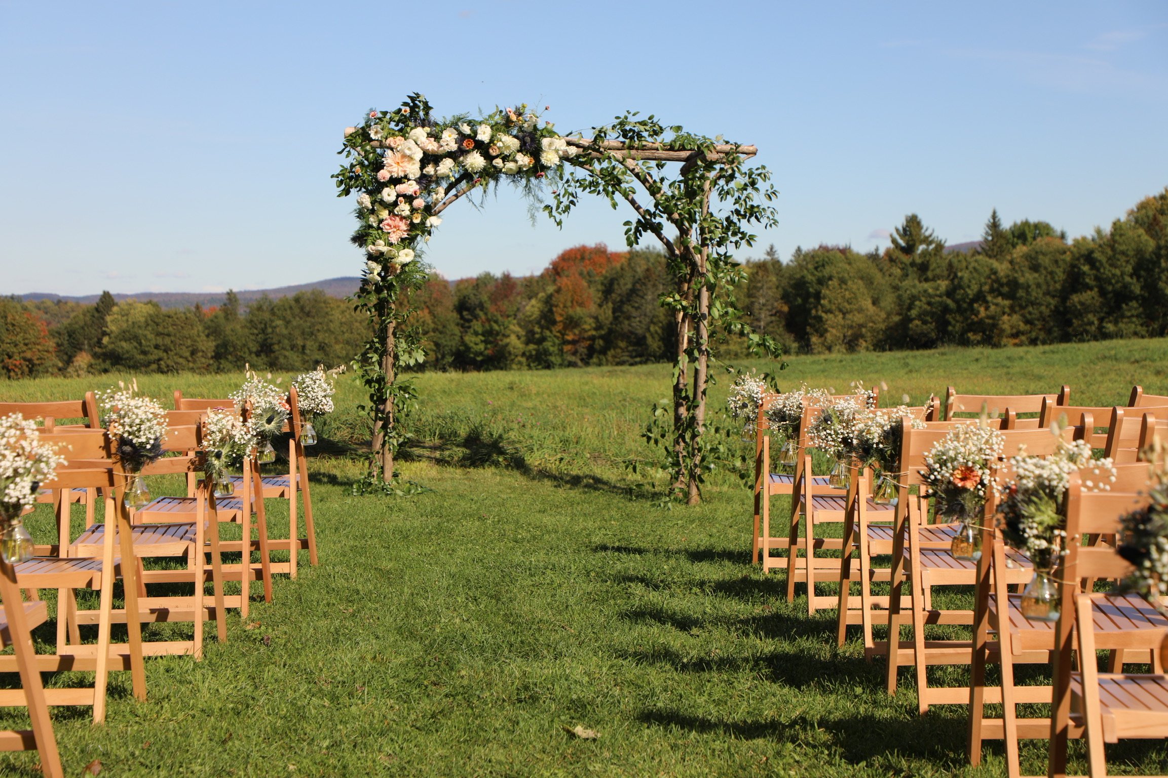 Flowered covered alter and chairs set up for a wedding