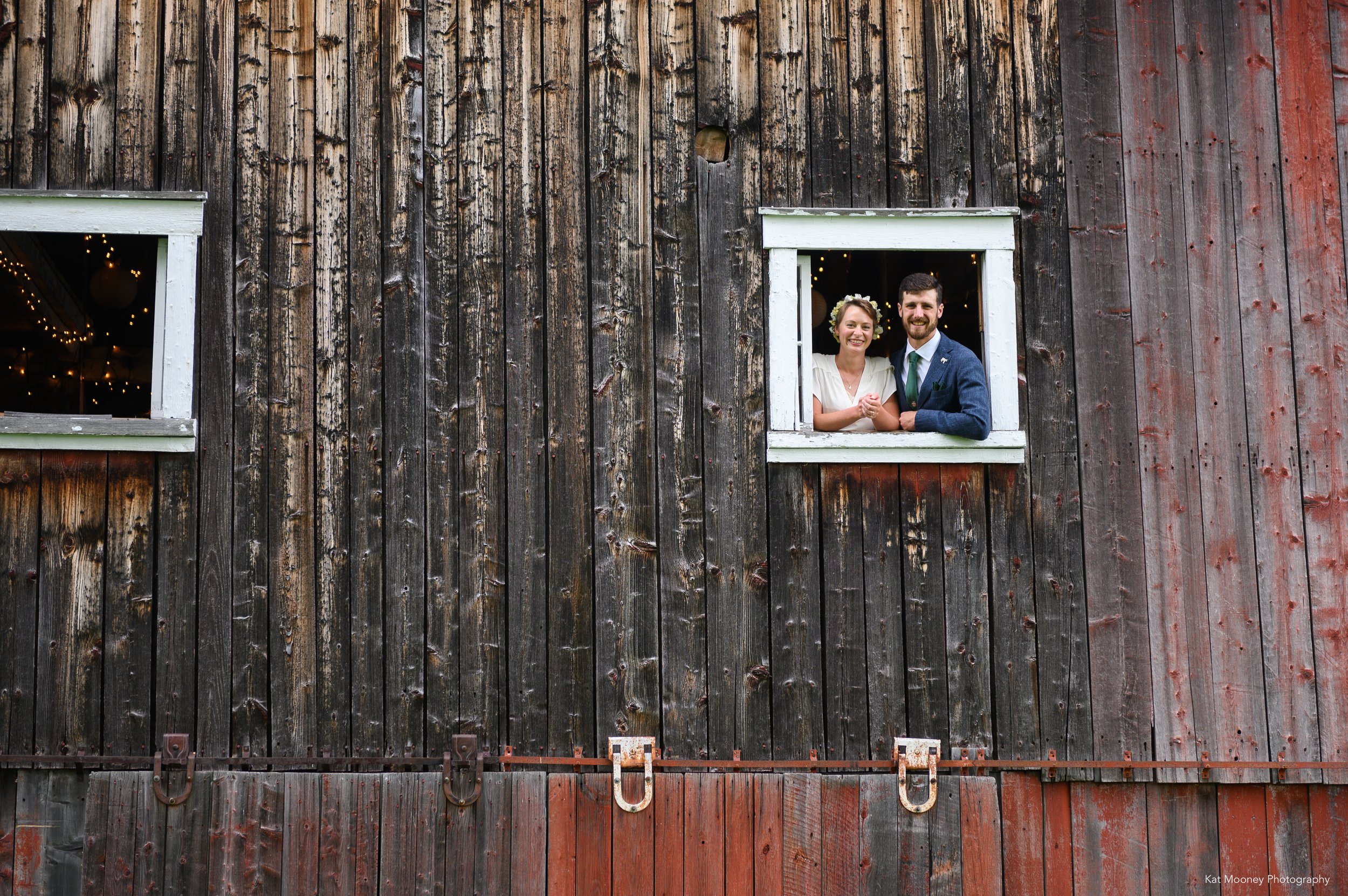 A newly married couple looking out the window of a rustic Vermont Barn