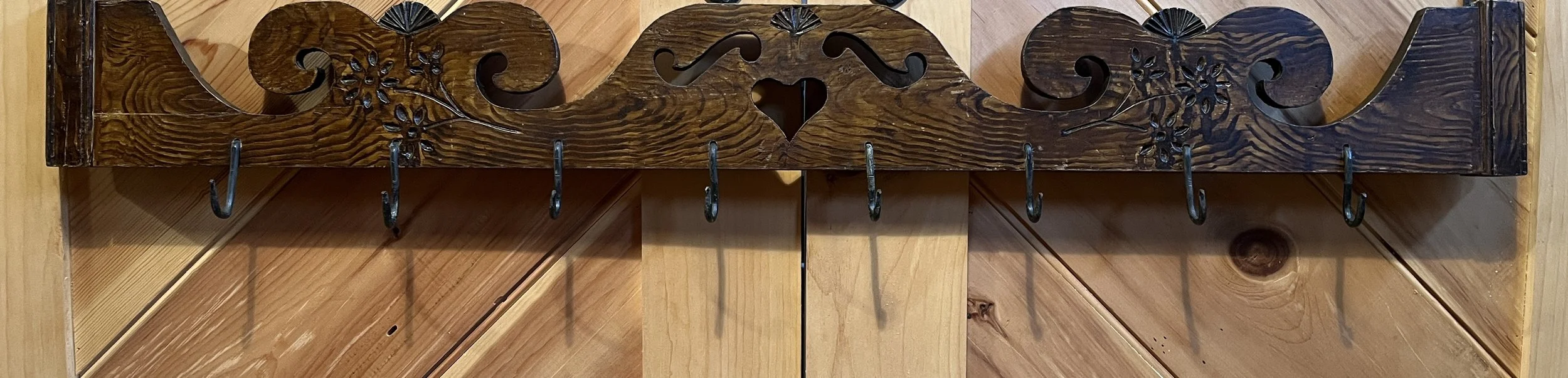 Hanging Rack: Repurposed cupboard crown, with original grain paint, 50 1/2” w x 6”h (7 3/4” h bottom of hook). Early hooks added to make hanger/drying rack for herbs, etc. M-55 $175