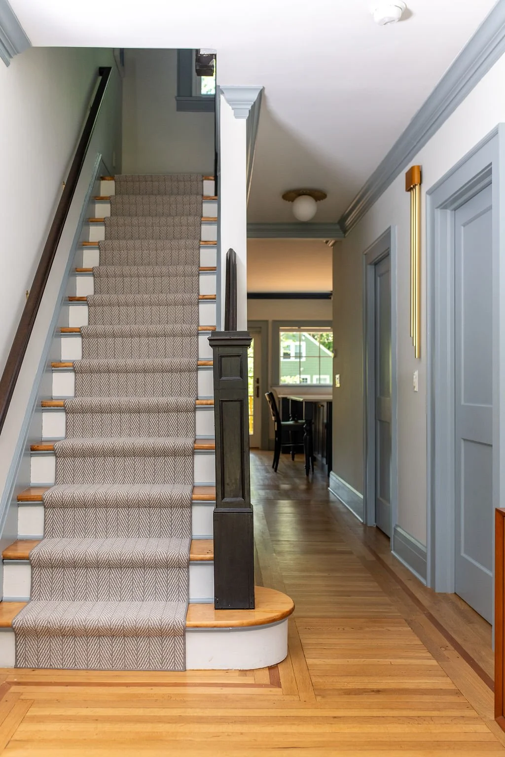   Entry After:  Where that overstuffed closet once stood, there's now a light filled hallway leading toward the kitchen. The family's new bedroom entrance sits just out of sight from the main living space, giving their aging parent privacy from the m