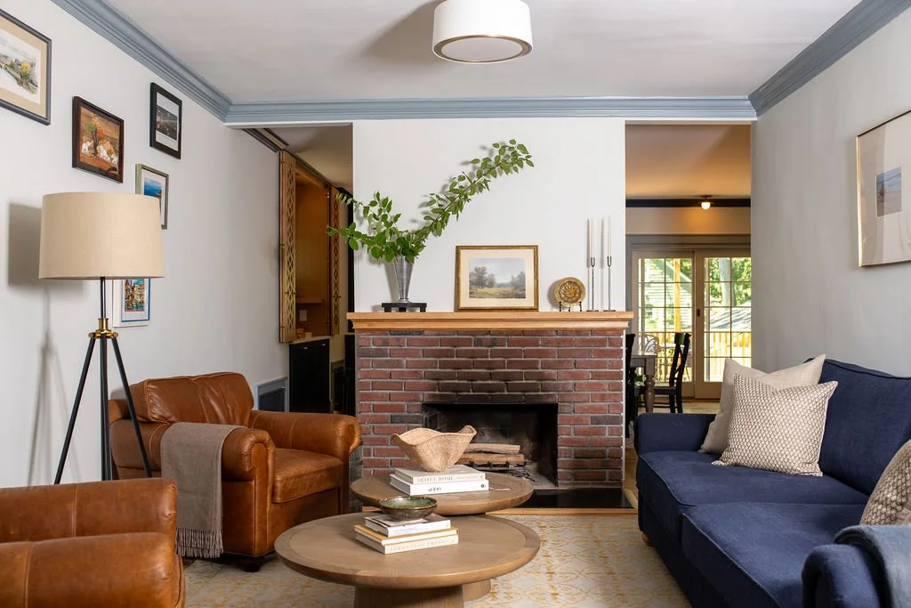   Living Room After:  Openings on either side of the fireplace now connect the living room straight into the dining room beyond. The fireplace, with its original 100 year old brick and texture, has become the anchor the family gathers around, visible
