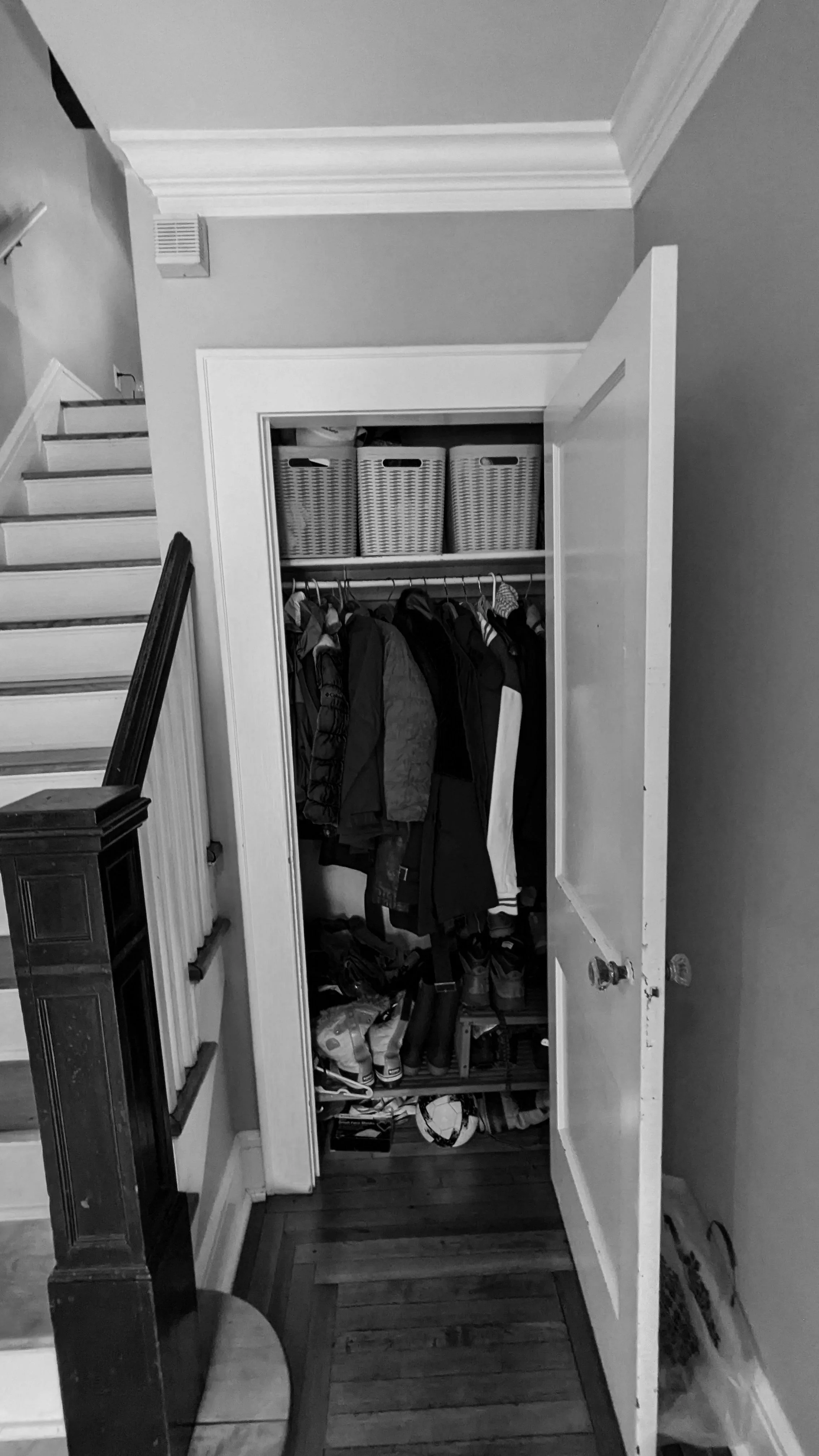   Entry Before:  The original entry greeted visitors with a run of stairs and a coat closet that was bursting at the seams. It was the first impression of the house, and it wasn't doing the family any favors. 
