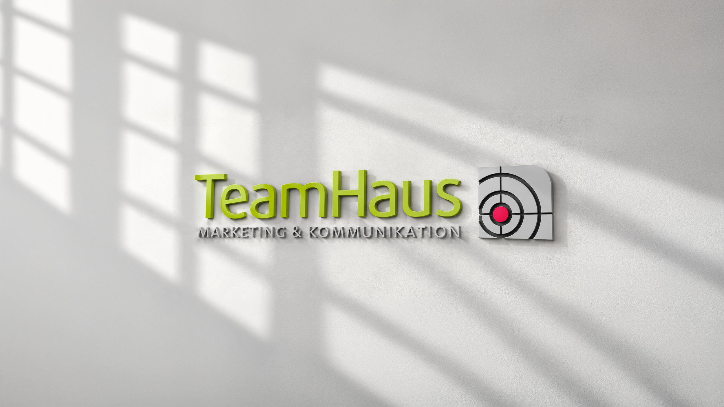 TeamHaus Wandlogo im modernen Büroo.png