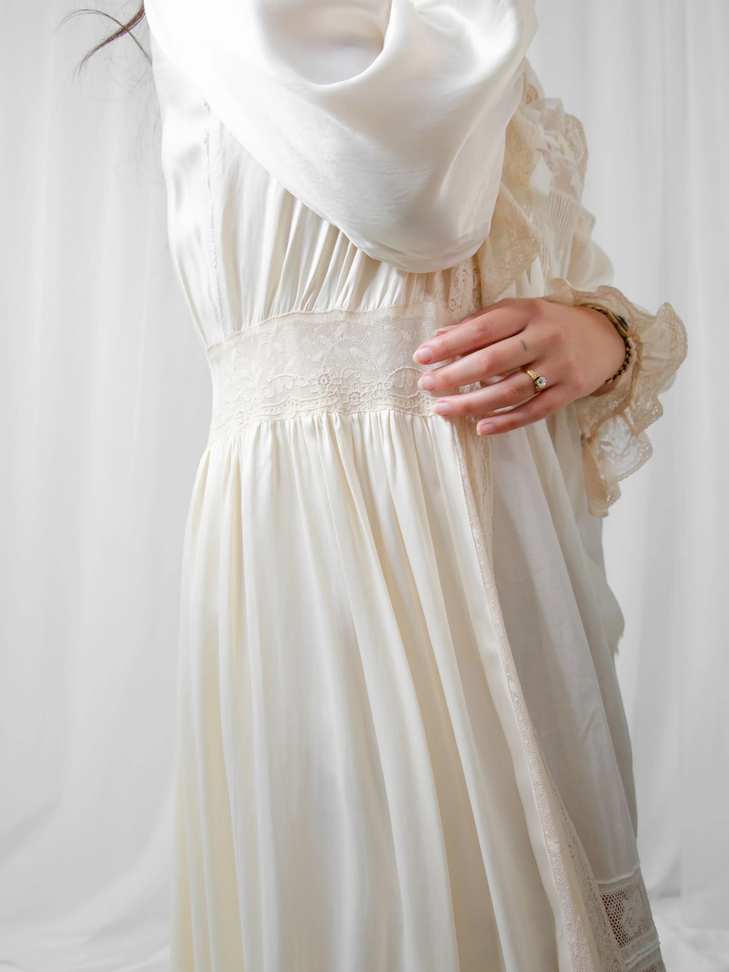 Close-up of the 1940s satin bridal robe on a model, showing the lace waist panel and lace sleeve cuff.