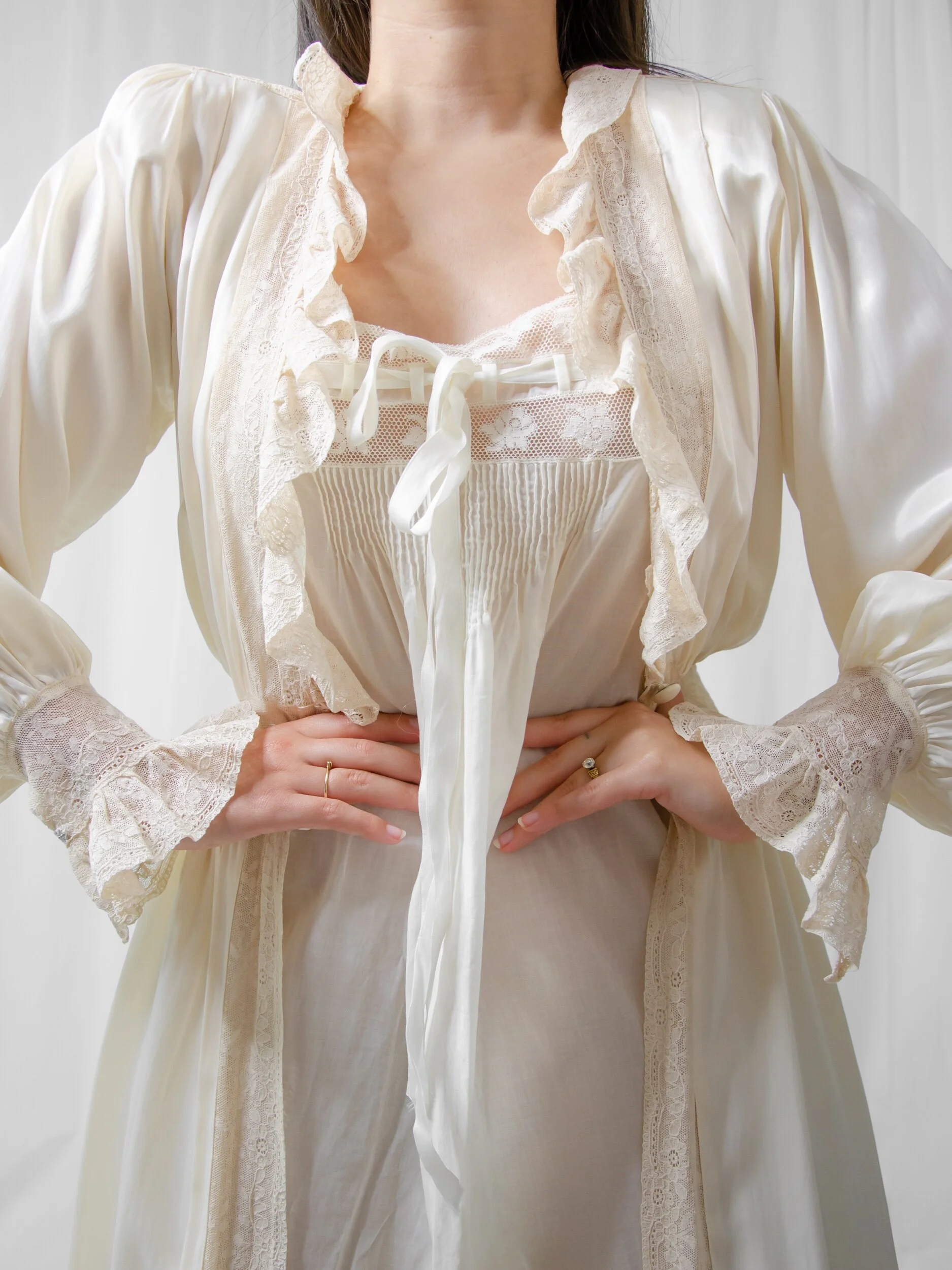 1940s eggshell satin bridal robe worn open on a model, showing the ruffled lace collar and lace cuffs.