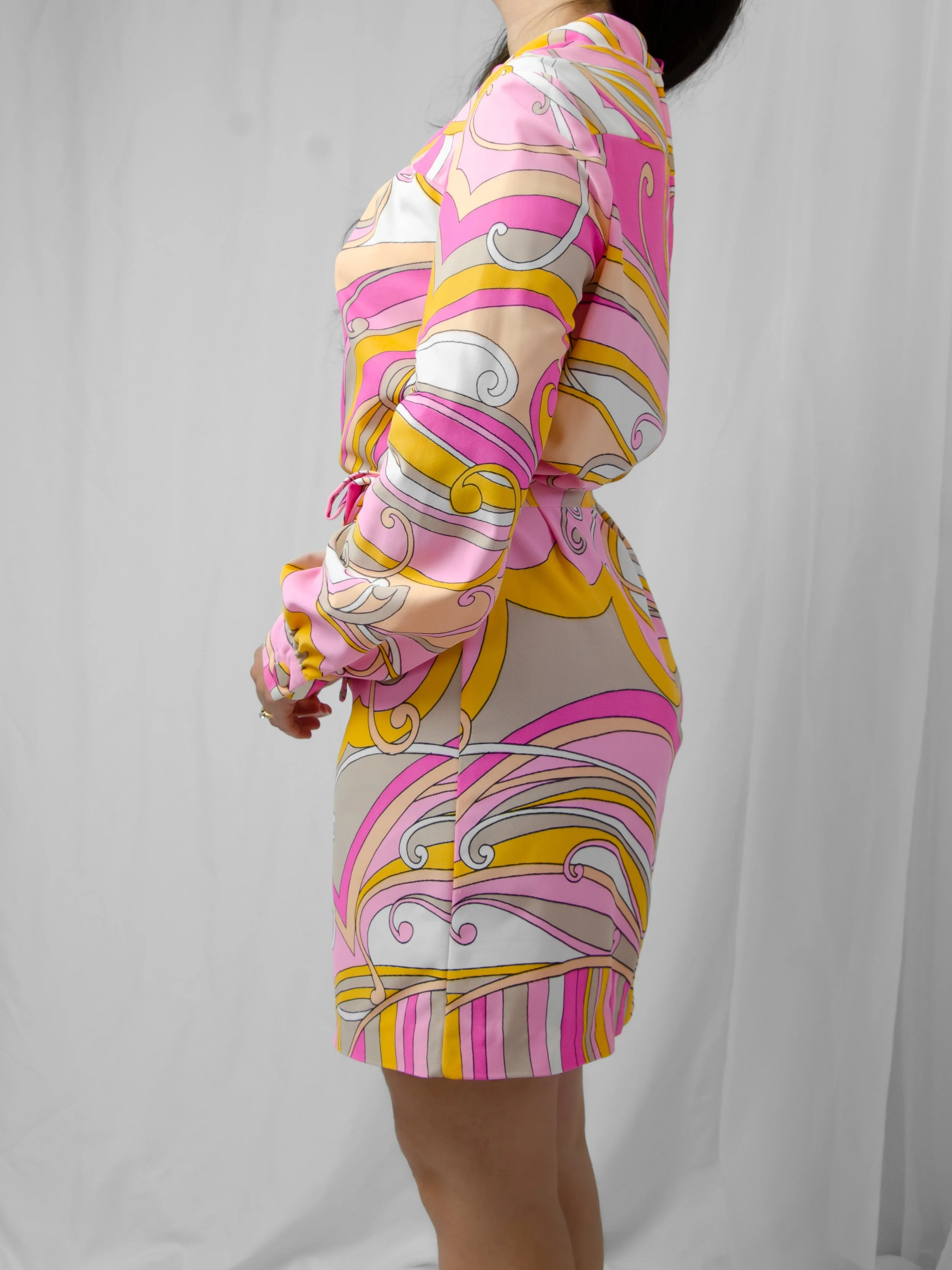 Side view of the 1960s pink and marigold swirl mini shift dress on a model.