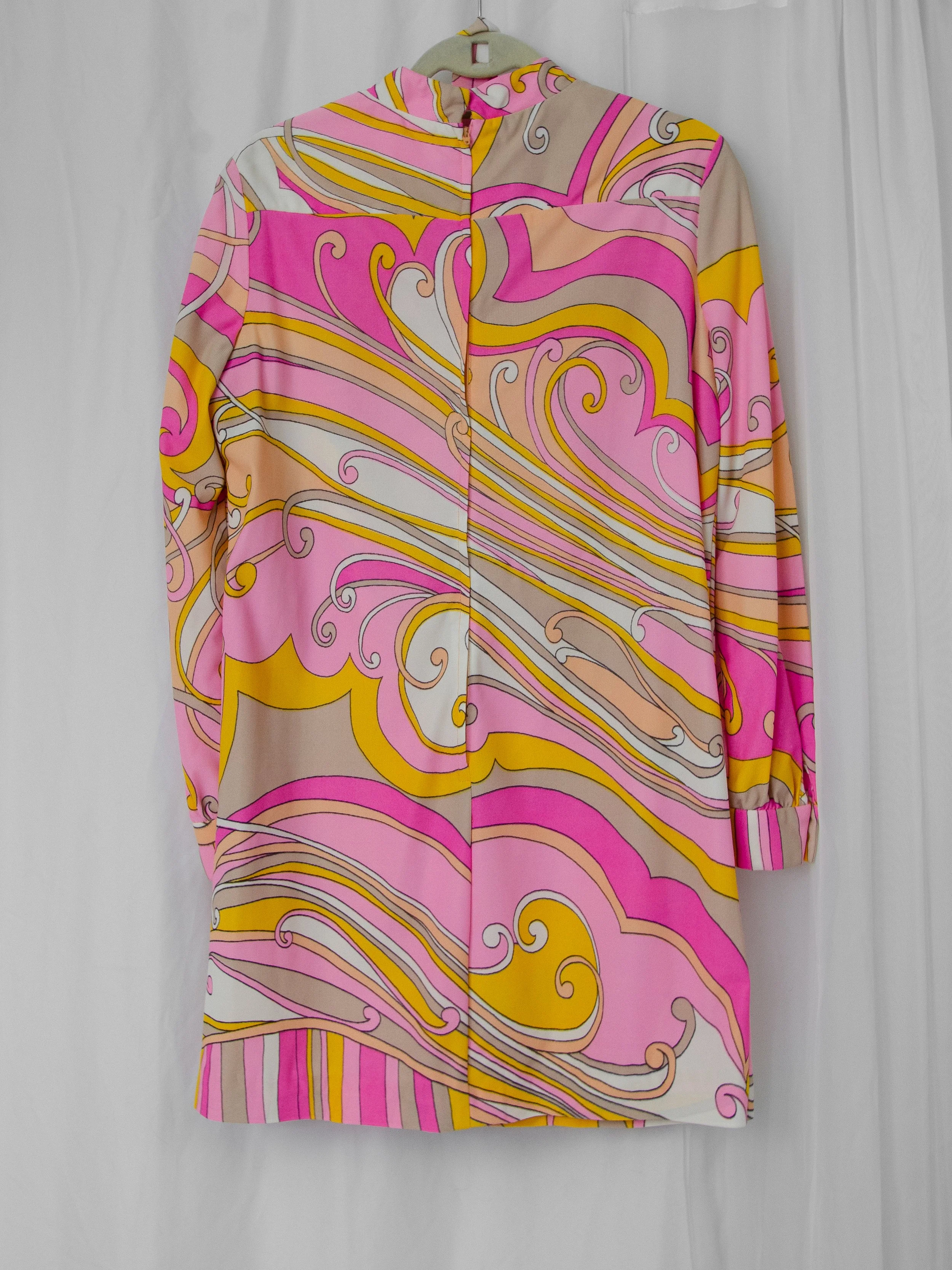 Back view of the 1960s psychedelic swirl dress on a hanger, showing the long back zipper.