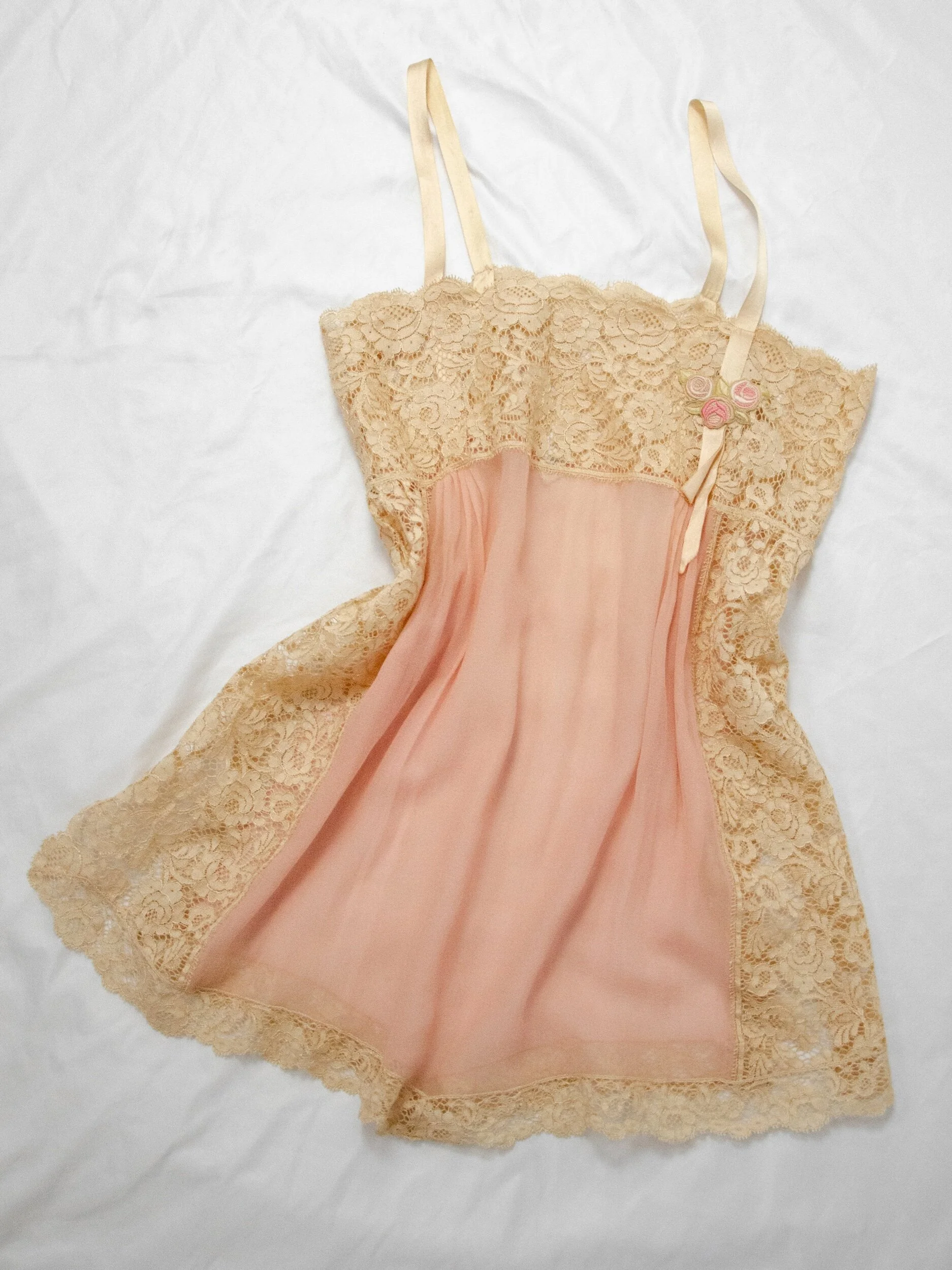 1920s dusty rose silk step-in teddy with wide ecru cotton lace trim, laid flat, front view.