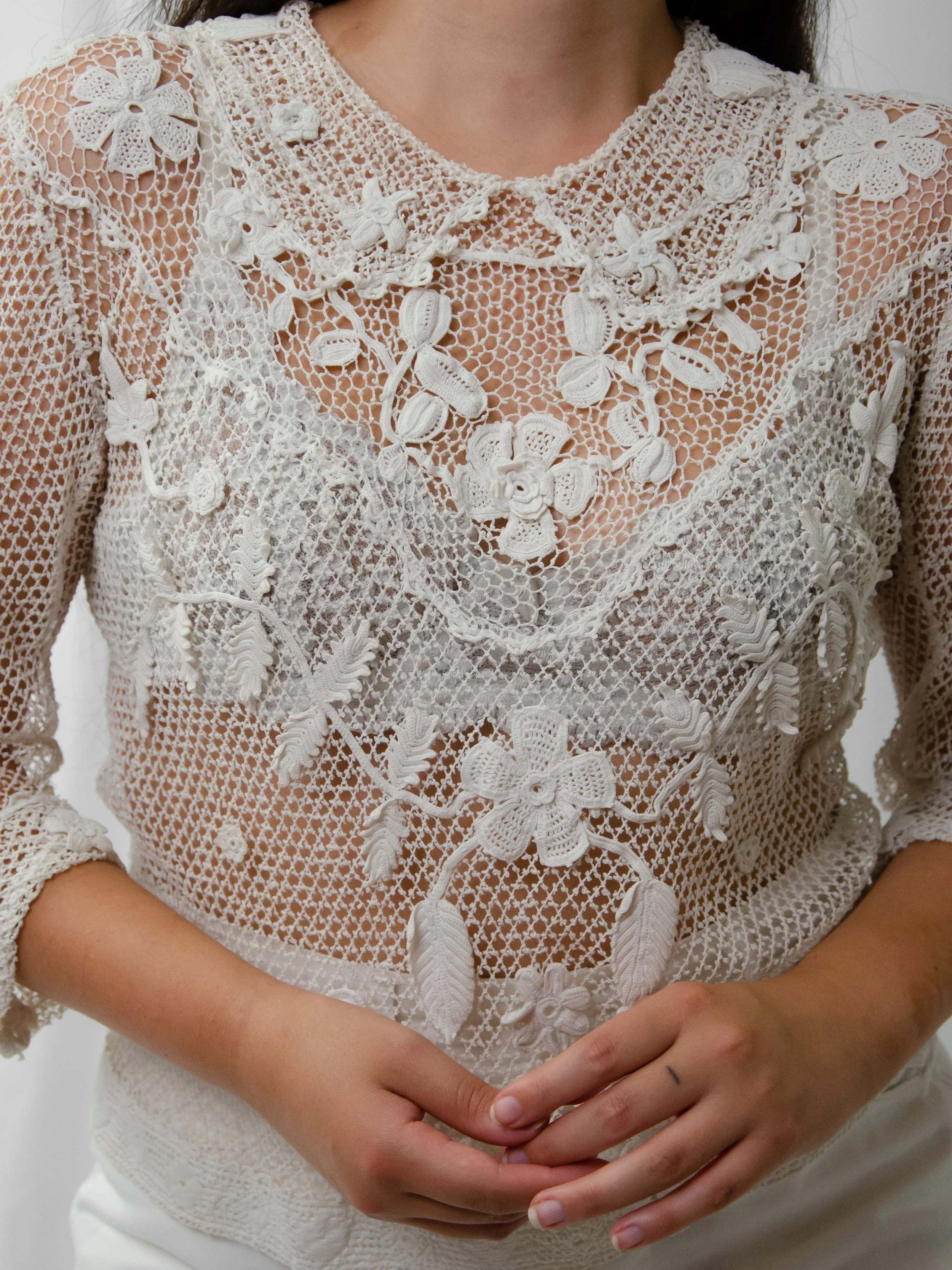 Close-up of the 1900s-1910s warm white Irish crochet top on a model, showing floral appliqué yoke.