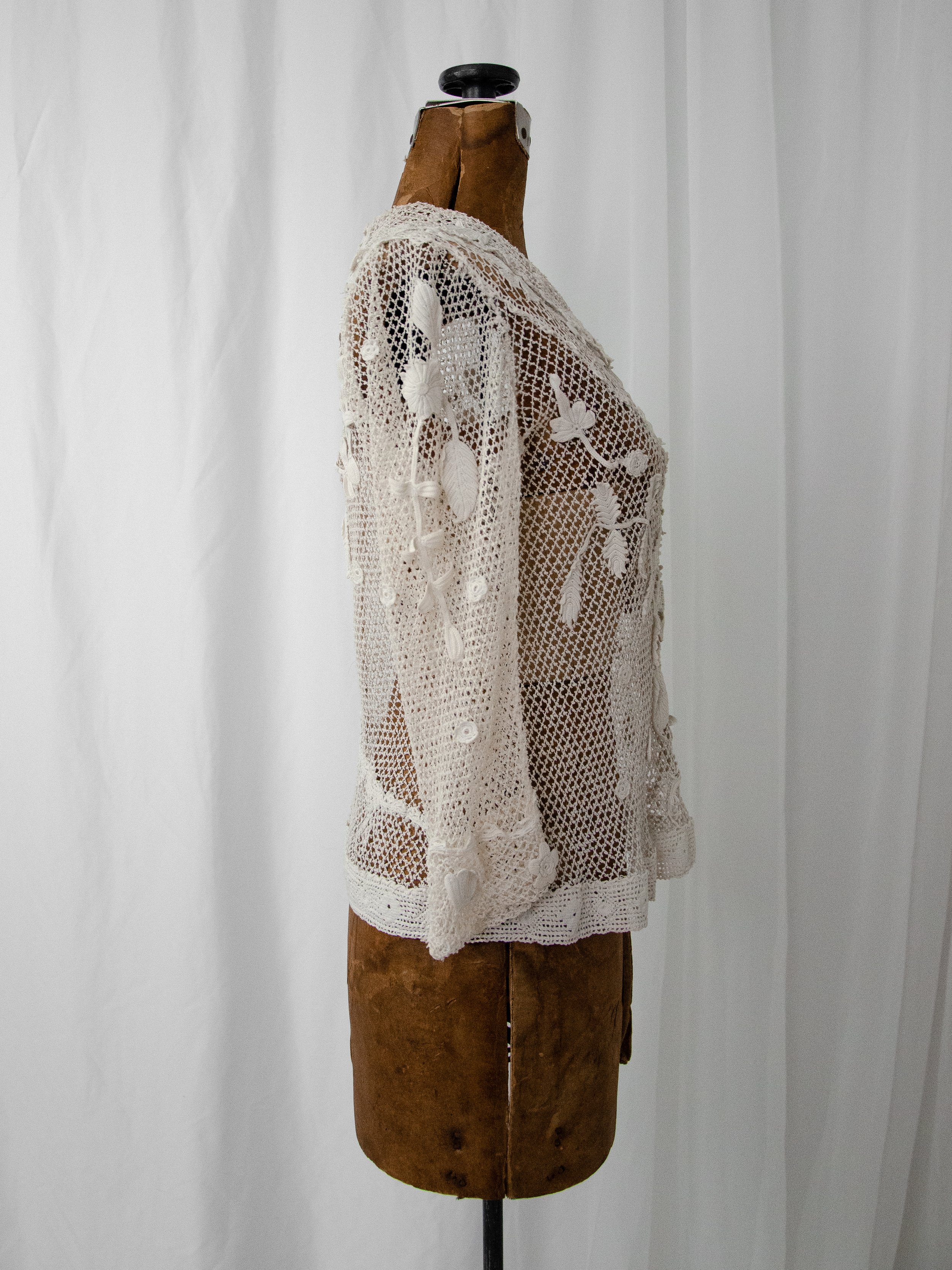 Side view of the 1900s-1910s Irish crochet top on a dress form, showing its fitted silhouette.