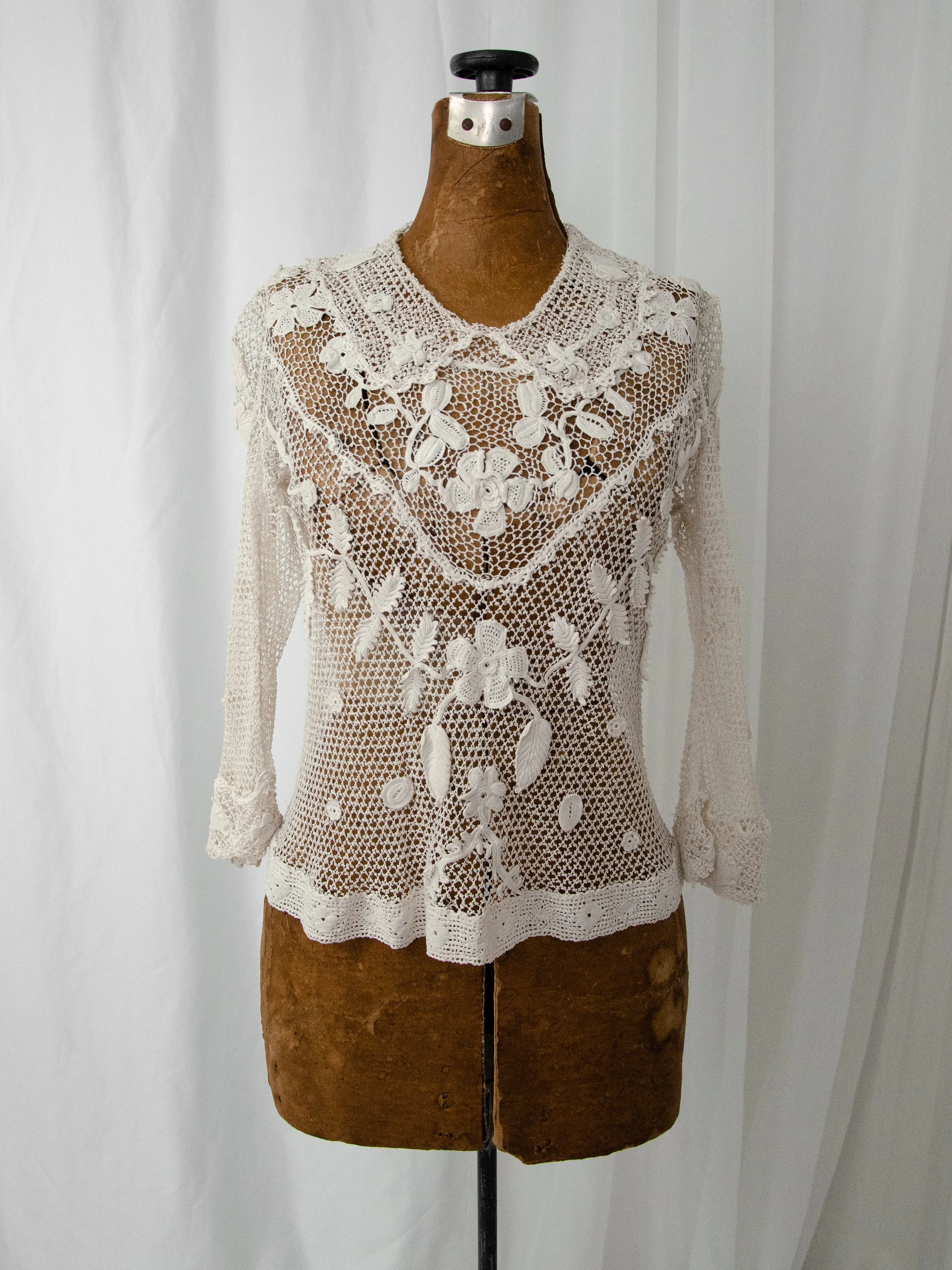 Front view of the antique white Irish crochet top on a dress form, showing the floral V-shaped yoke.