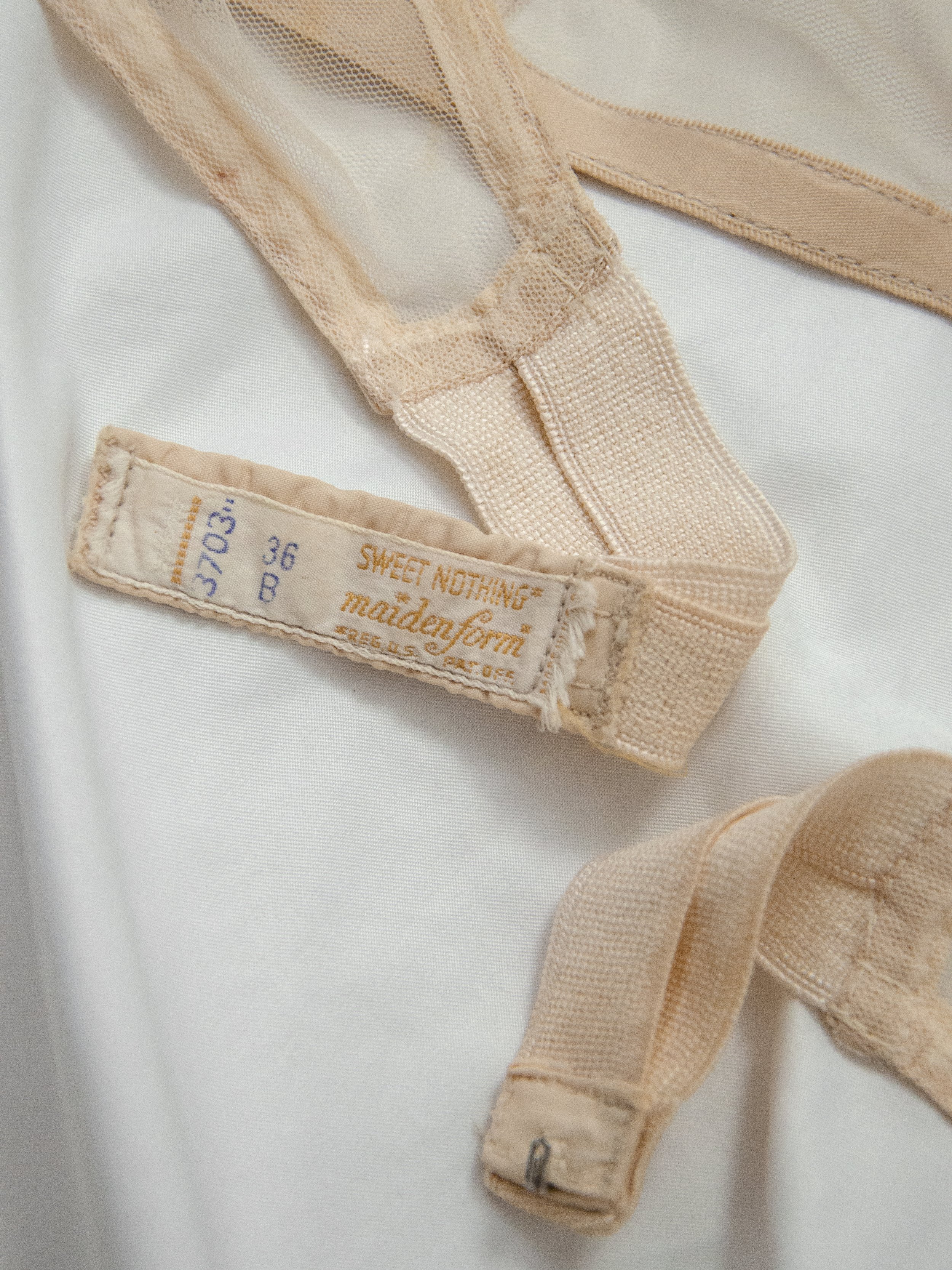 Detail of the late 1940s Maidenform bra's back band showing the size 36B label and hook closure.