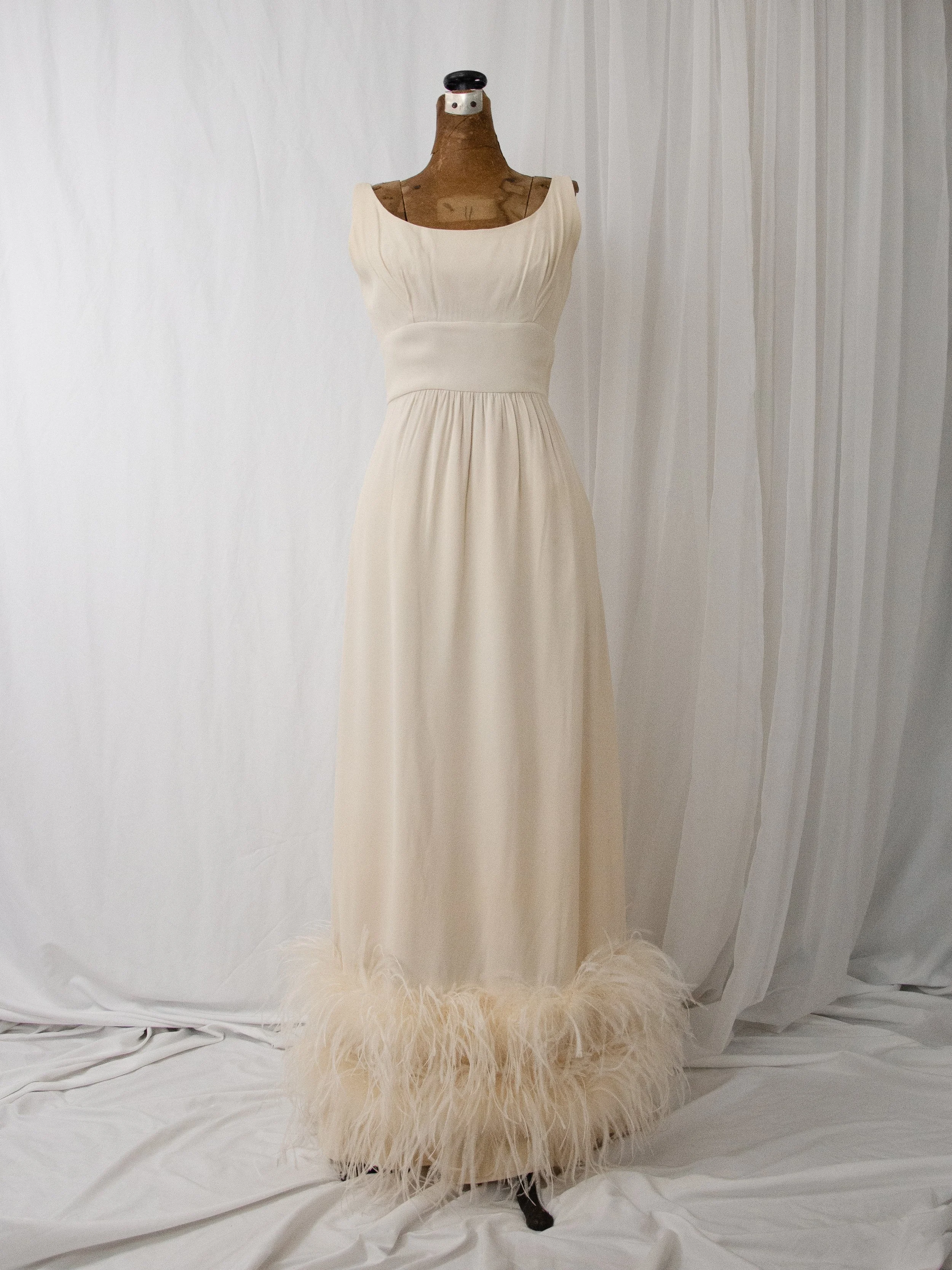 Front view of the late 1950s cream ostrich feather gown on a dress form, showing the column silhouette.